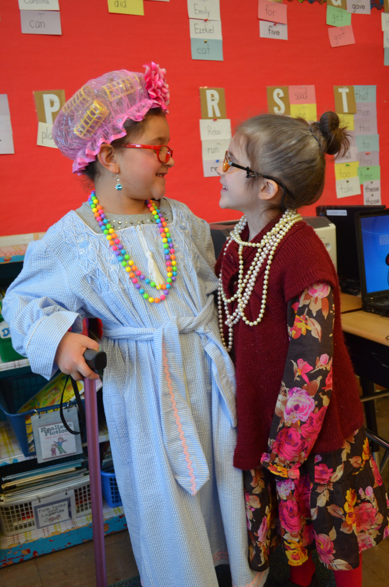 Carolina Figueroa, 7, at left, and Emily Carr, 6, of Ms. Anderson’s first grade class dressed up as 100-year-old women to celebrate.