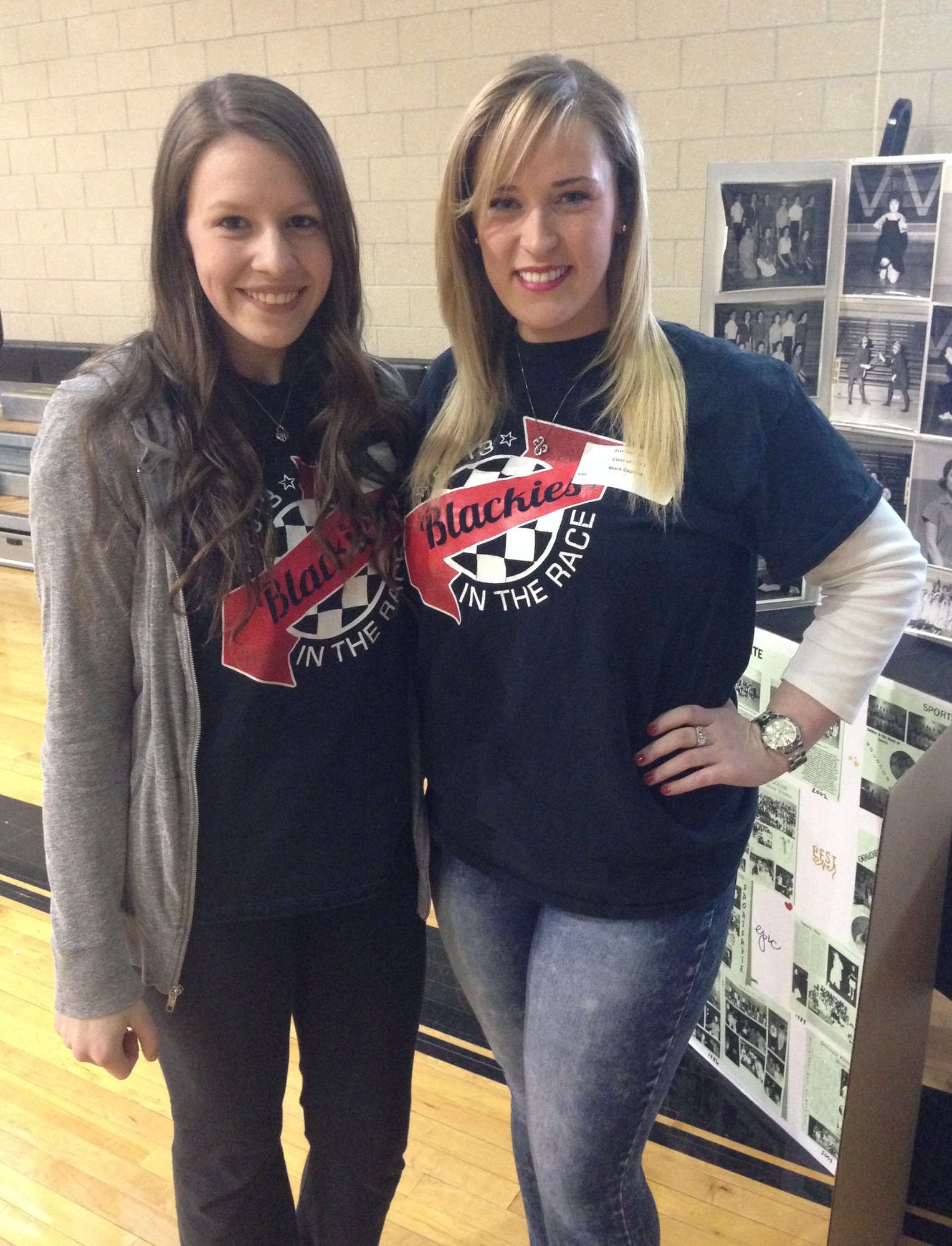 Grace Hostetter and Erin Gallagher, who captained the Black team in 2013, stood near some of the old photos on display.