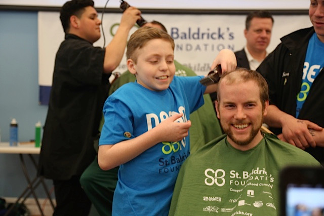 Cancer Survivor Doug Gonzalez shaved the head of his second-grade teacher Keith Eckert.