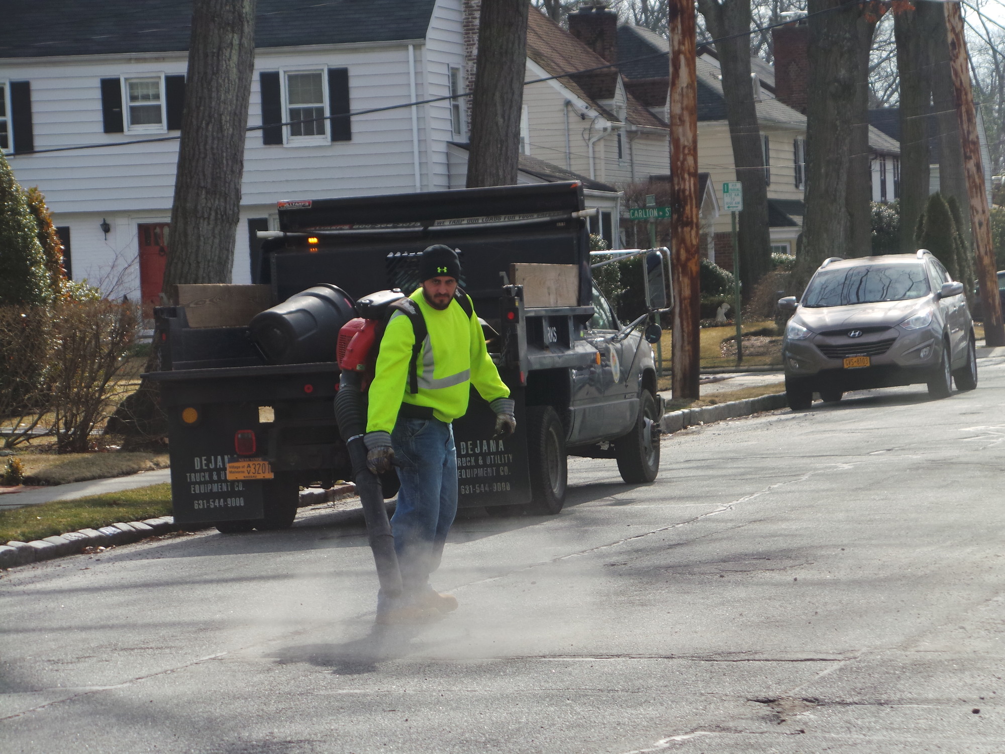 Nick Lavrigata blows the debris away from a Webster Street pothole.