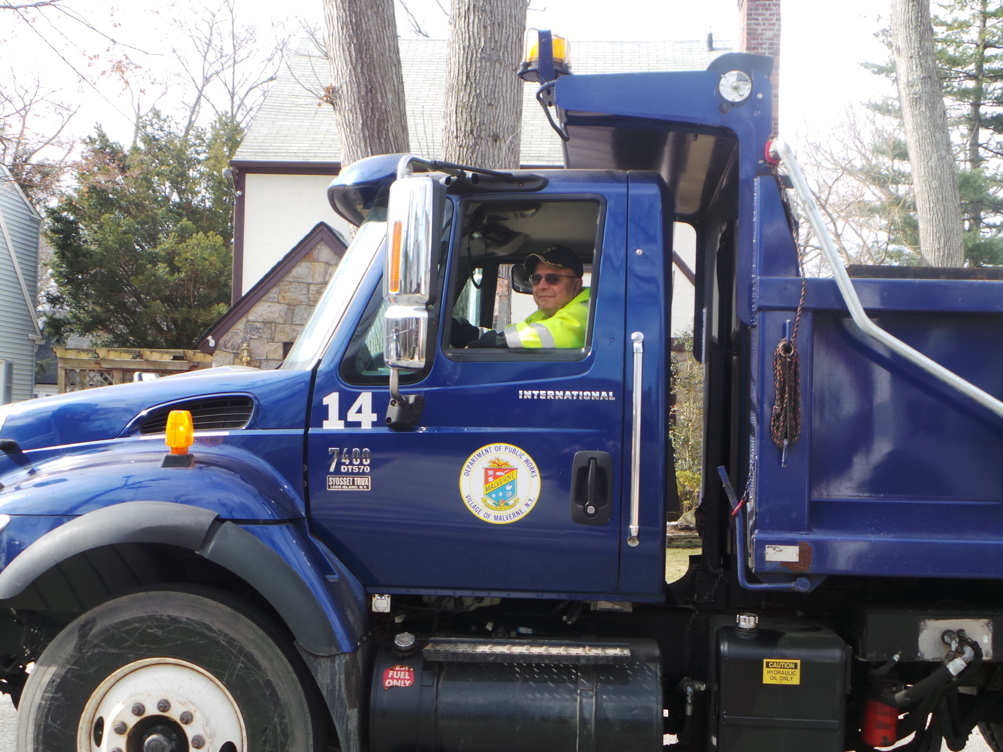 Jerry Cardella, 
a senior member of the DPW, drives the truck that hauls four tons of asphalt. He  also  drives the village street sweeper.