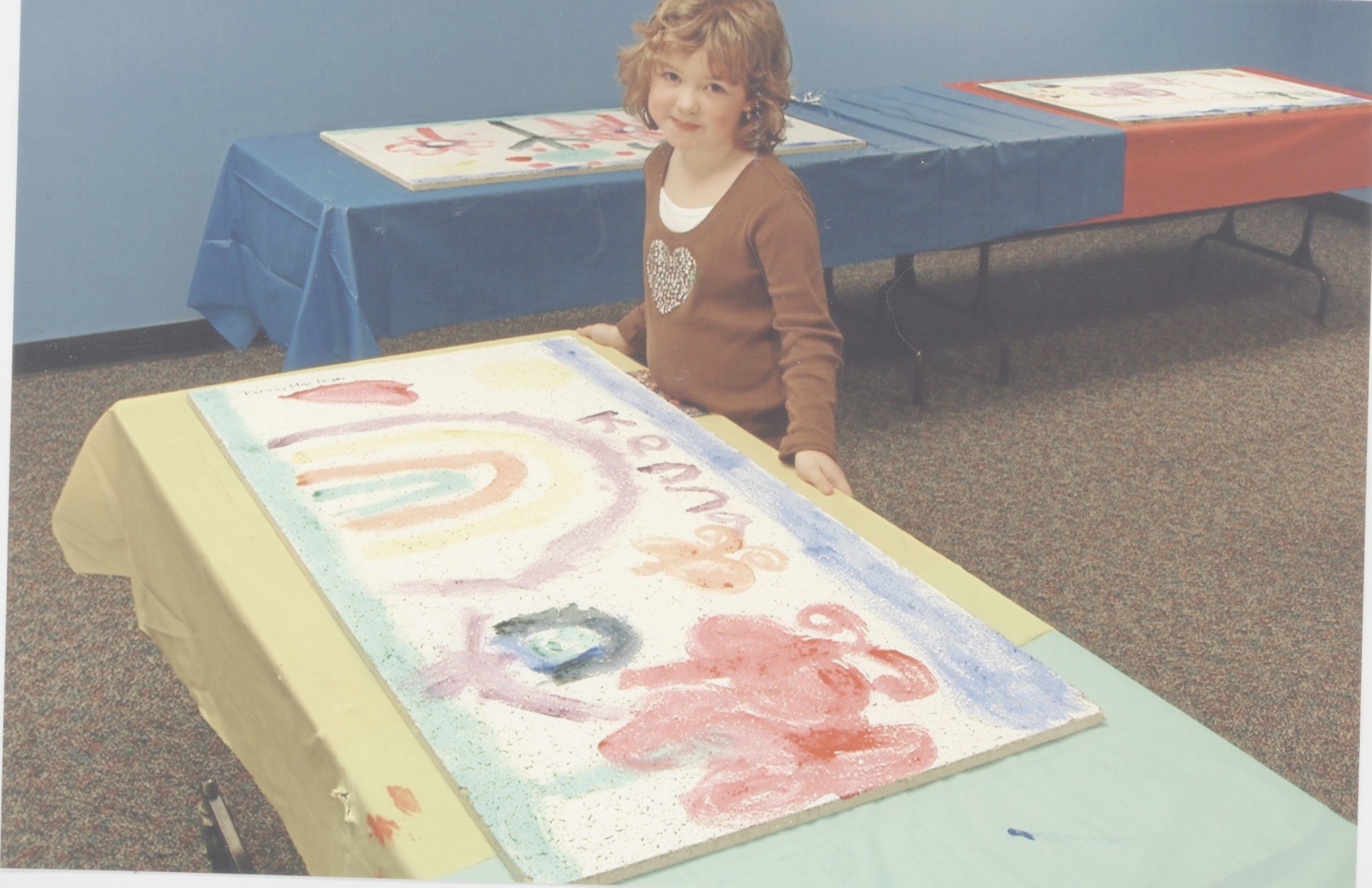 Eight years ago, Kenna MacLean was one of nearly 100 children who painted a ceiling tile, which are spread throughout the library’s lower level.
