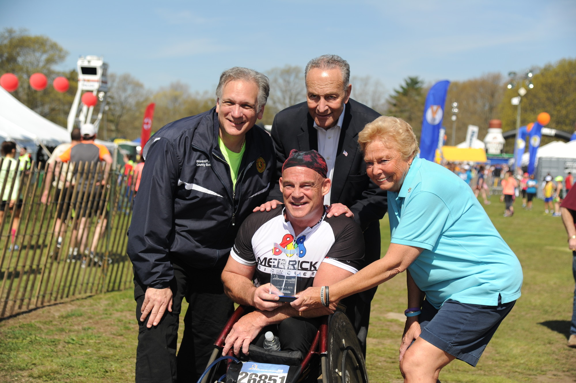 Peter Hawkins, of Malverne, crossed the finish line in two hours and ten minutes to win the wheelchair division. He was congratulated by Nassau County Executive Ed Mangano, at left, U.S. Sen. Charles Schumer and Nassau County Legislator Rose Walker.