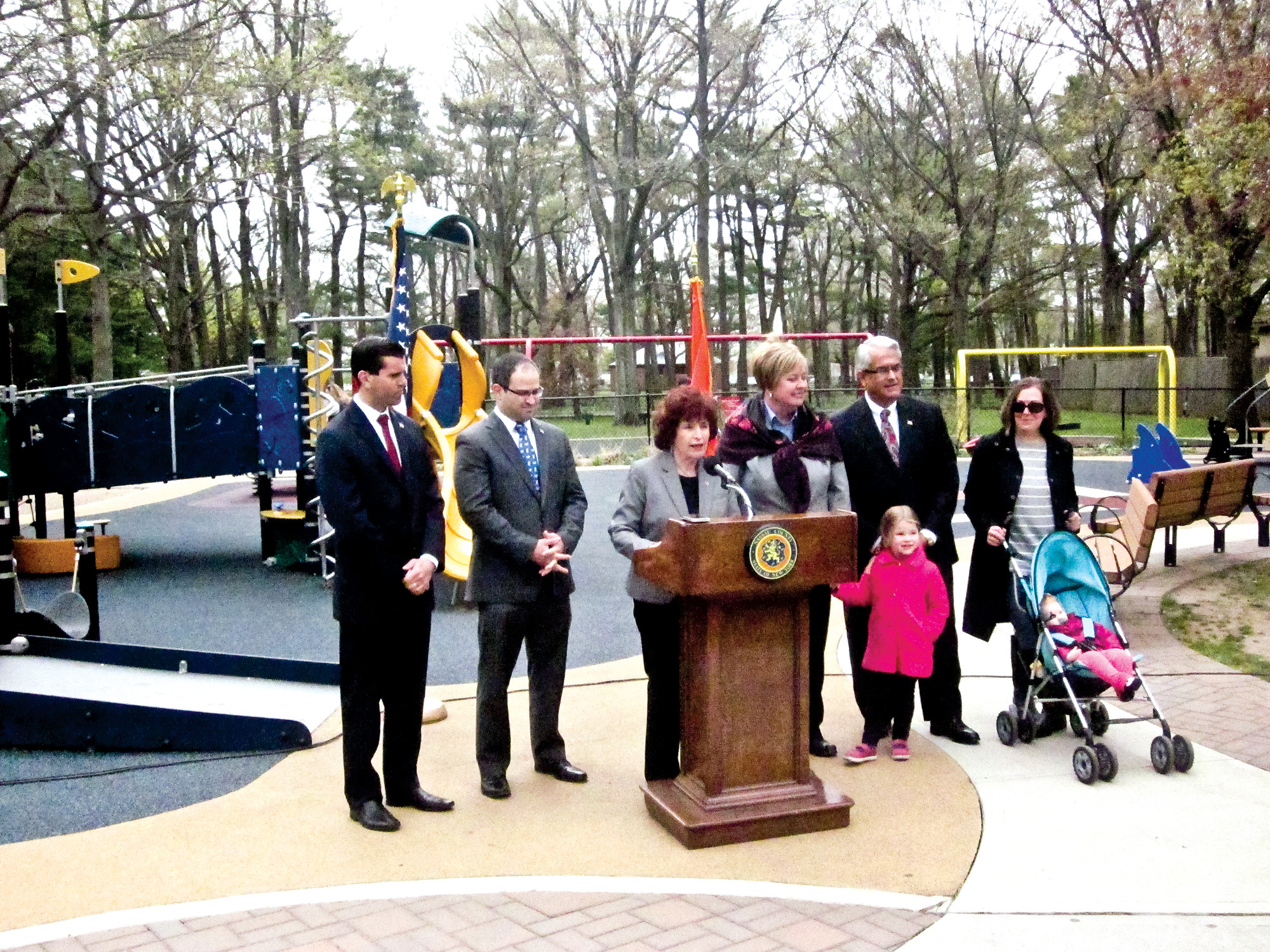 Norma Gonsalves, the presiding officer of the Nassau County Legislature, at the lectern, said county, town and state officials are working together to push legislation that would give local municipalities the power to enforce their own codes to impose residency restrictions on convicted sex offenders. She was joined in Eisenhower Park’s Field 2 by State Sen. Michael Venditto, far left, Assemblyman Ed Ra, Town of Hempstead Supervisor Kate Murray, Councilman Anthony Santino, Kim Wipperman, of Massapequa, and children Annie and Ella Pokalsy, of Seaford.