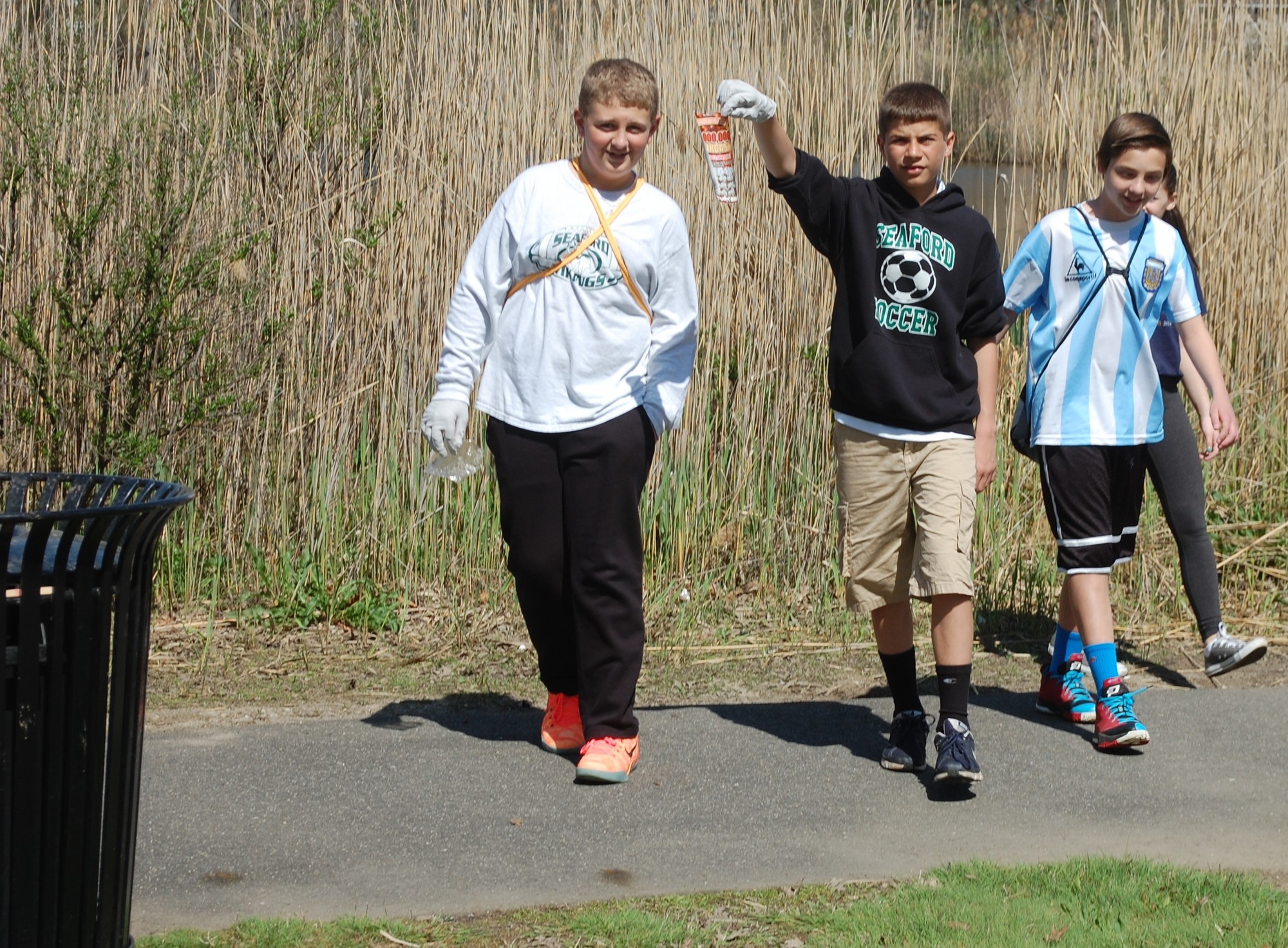 Mark Armano, center, emerged from the brush with his classmates with some garbage they found.