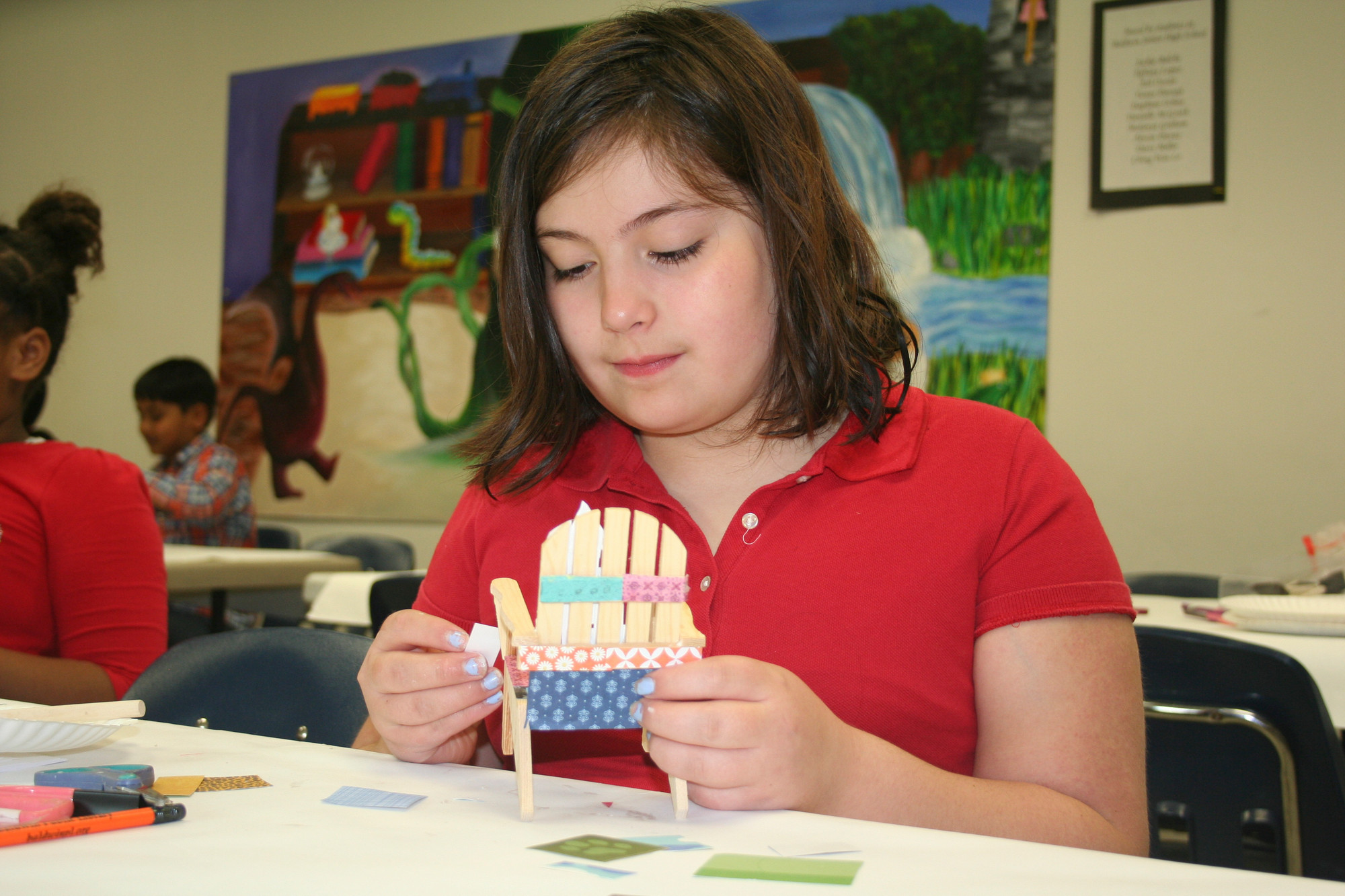 Arianna Rogers, 10, glued decorated paper to the tiny wooden lawn chair.