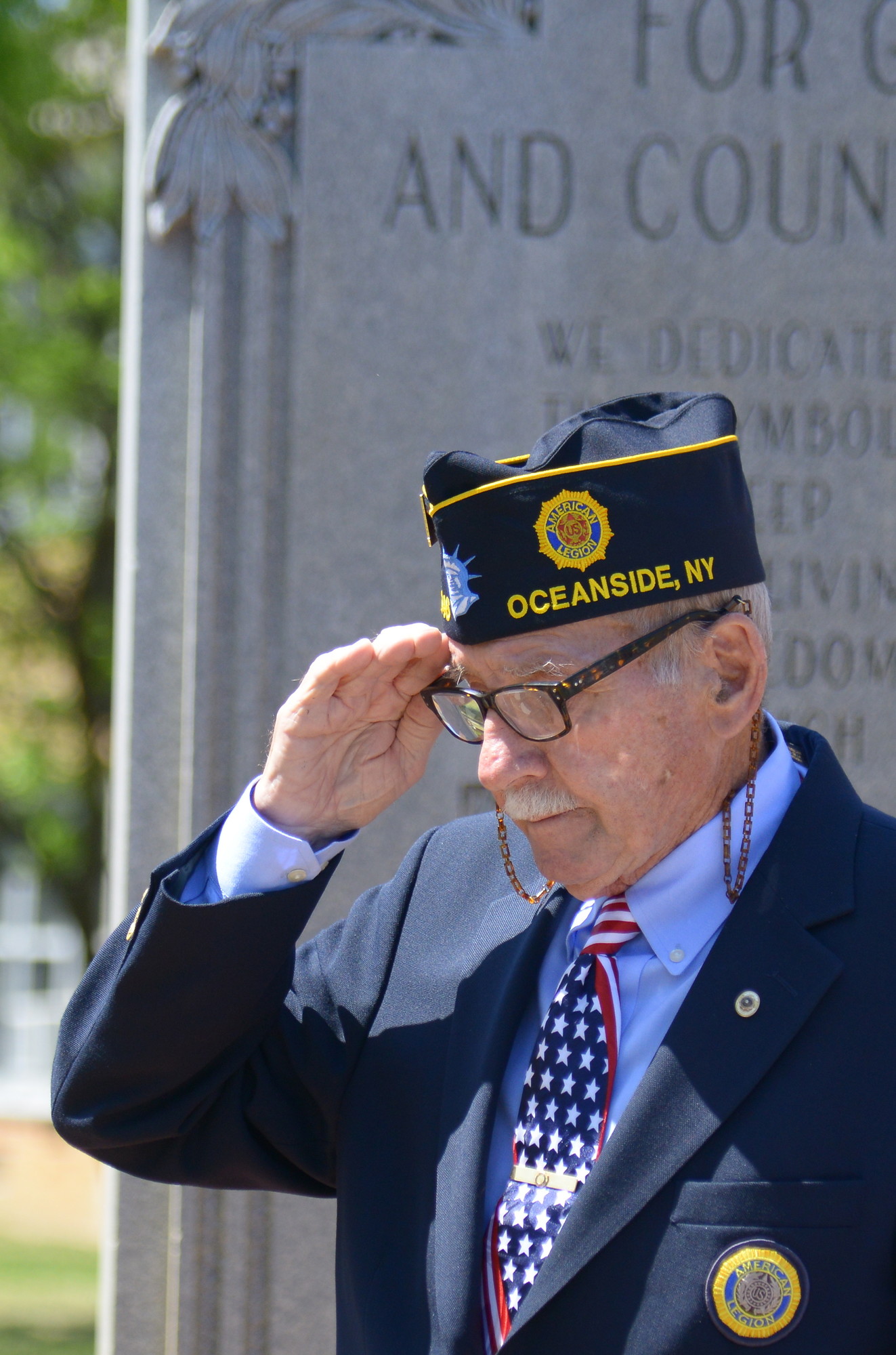 Master of Ceremonies Bill Davison, Commander American Legion Post 1246, salutes at the Memorial Day services held at Oceanside High School.