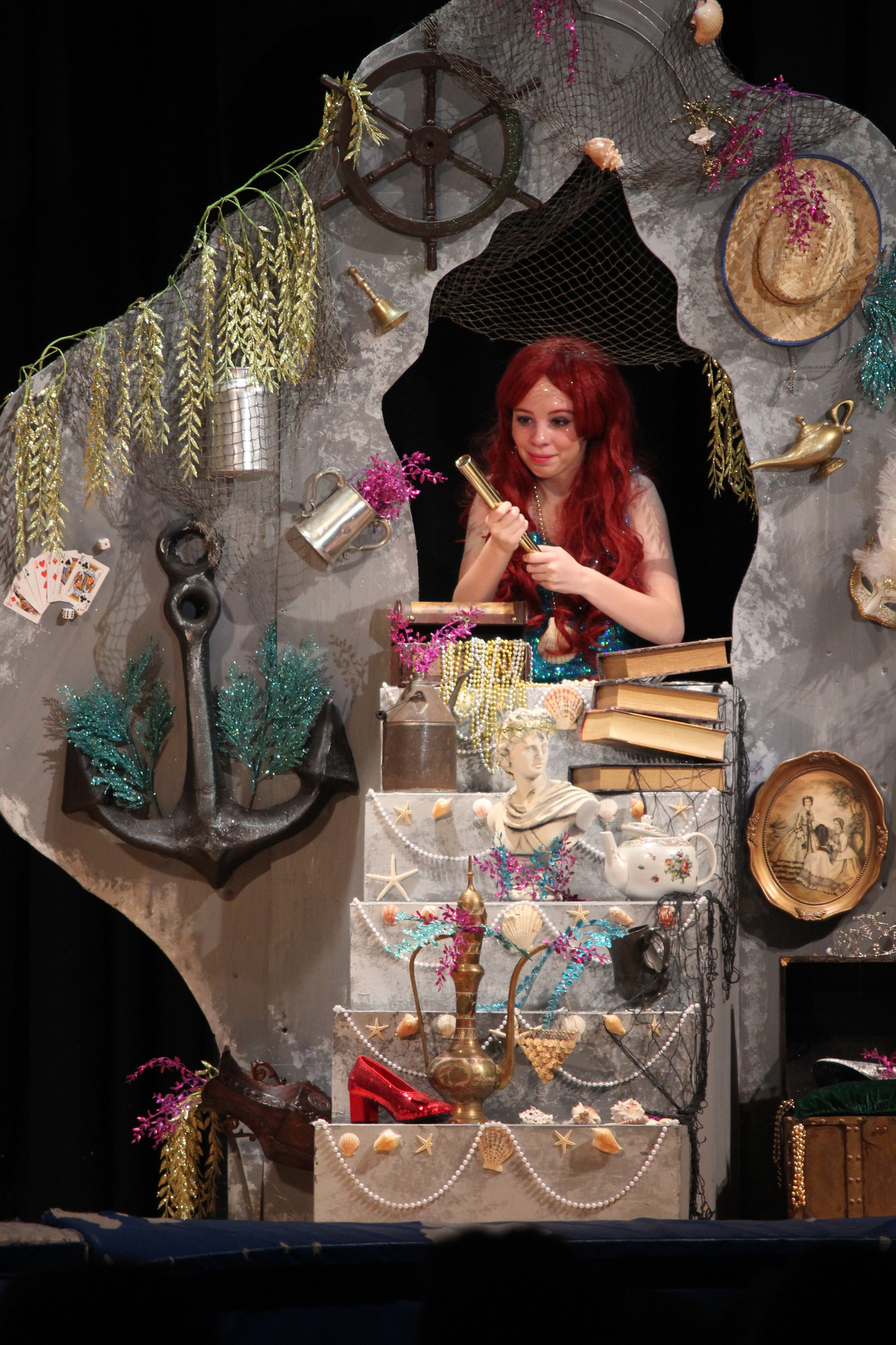 Ariel, played by Leana Genovese, admired the hidden treasures in her grotto.  Sets were designed by St. Agnes alum Colin O’Leary.