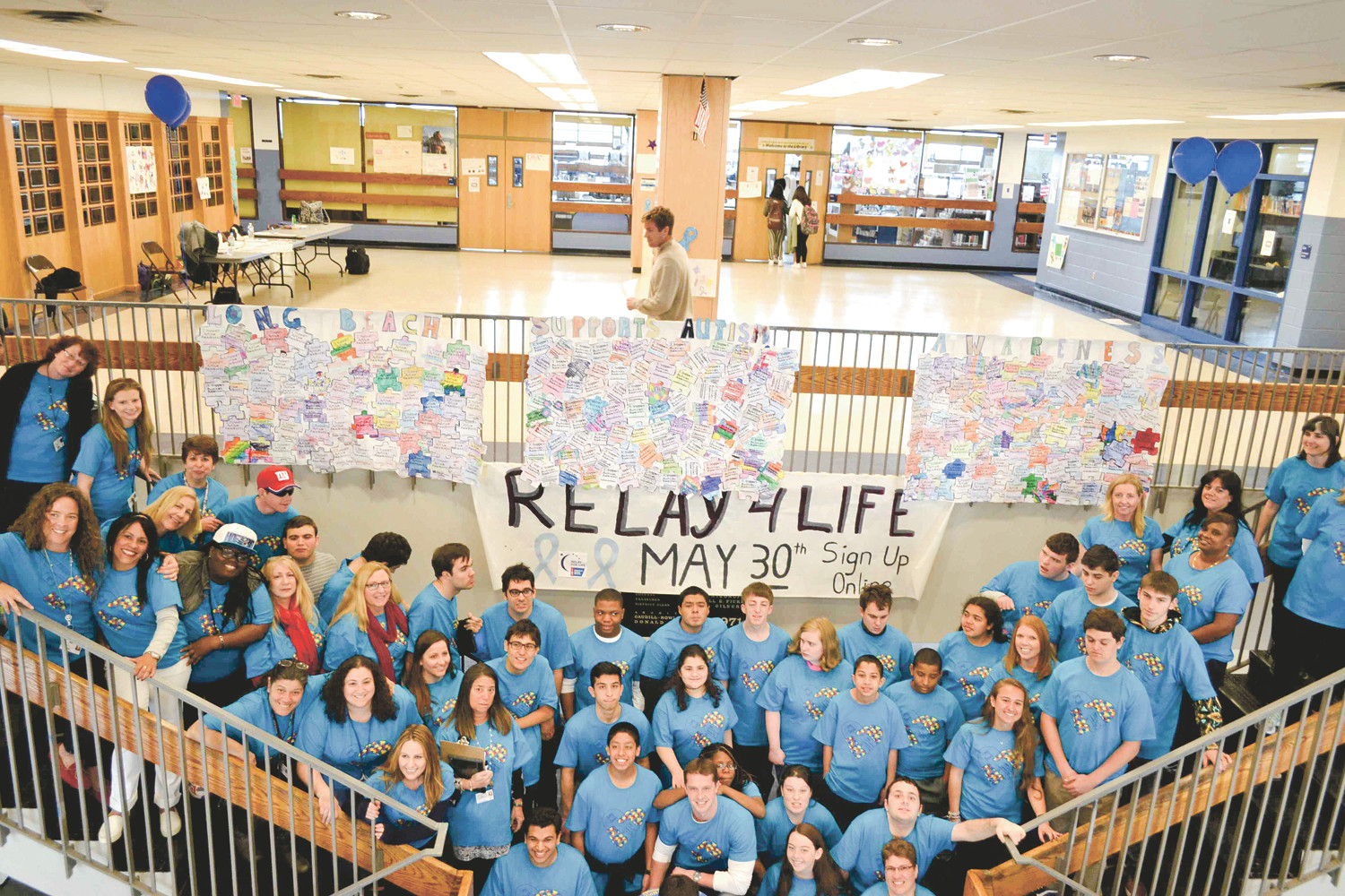 Courtesy Long Beach School District
Students from the Best Pals organization and Life Skills program gathered with staff members in the commons area of Long Beach High School, where a puzzle banner representing Autism Awareness Month hung in April.
