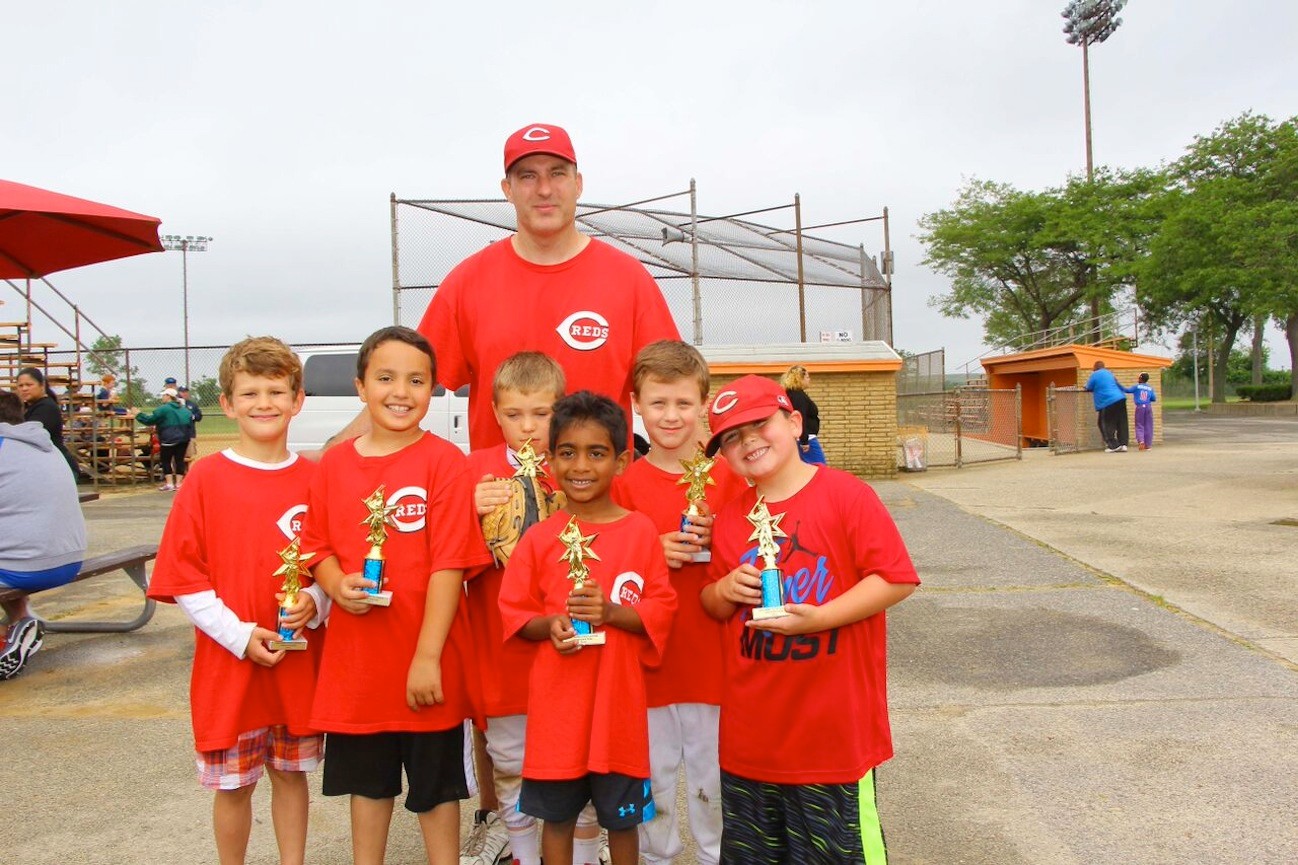 Reds coach Tom Reilly, and some of his Reds players, from left, Eric Reilly, 7, Justin Funkenberg, 7, Ryan Carney, 8,  Jadon Geevarghese, 7, Shane Harmon, 6, and Carter Krug, 6, showed off their new hardware.