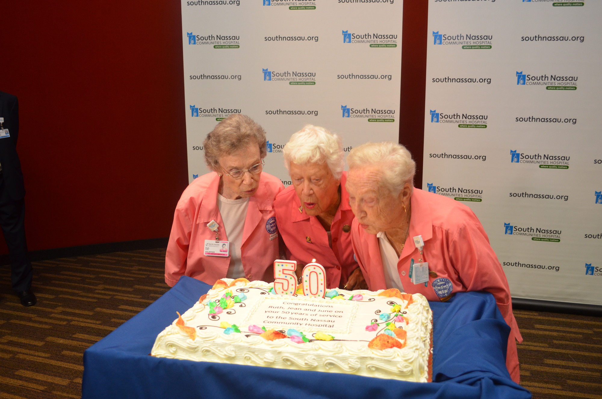 Ruth Fortin, June Kane and Jean Silvers celebrated 50 years of volunteering at South Nassau Communities Hospital by blowing out the candles on their cake.