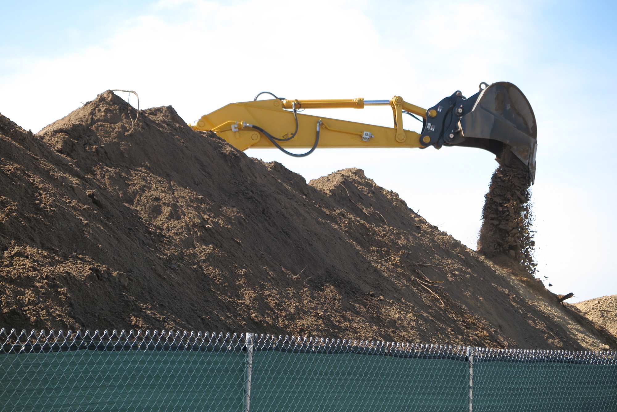 Dirt and debris from large construction mounds are being scattered by strong winds coming off the bay.