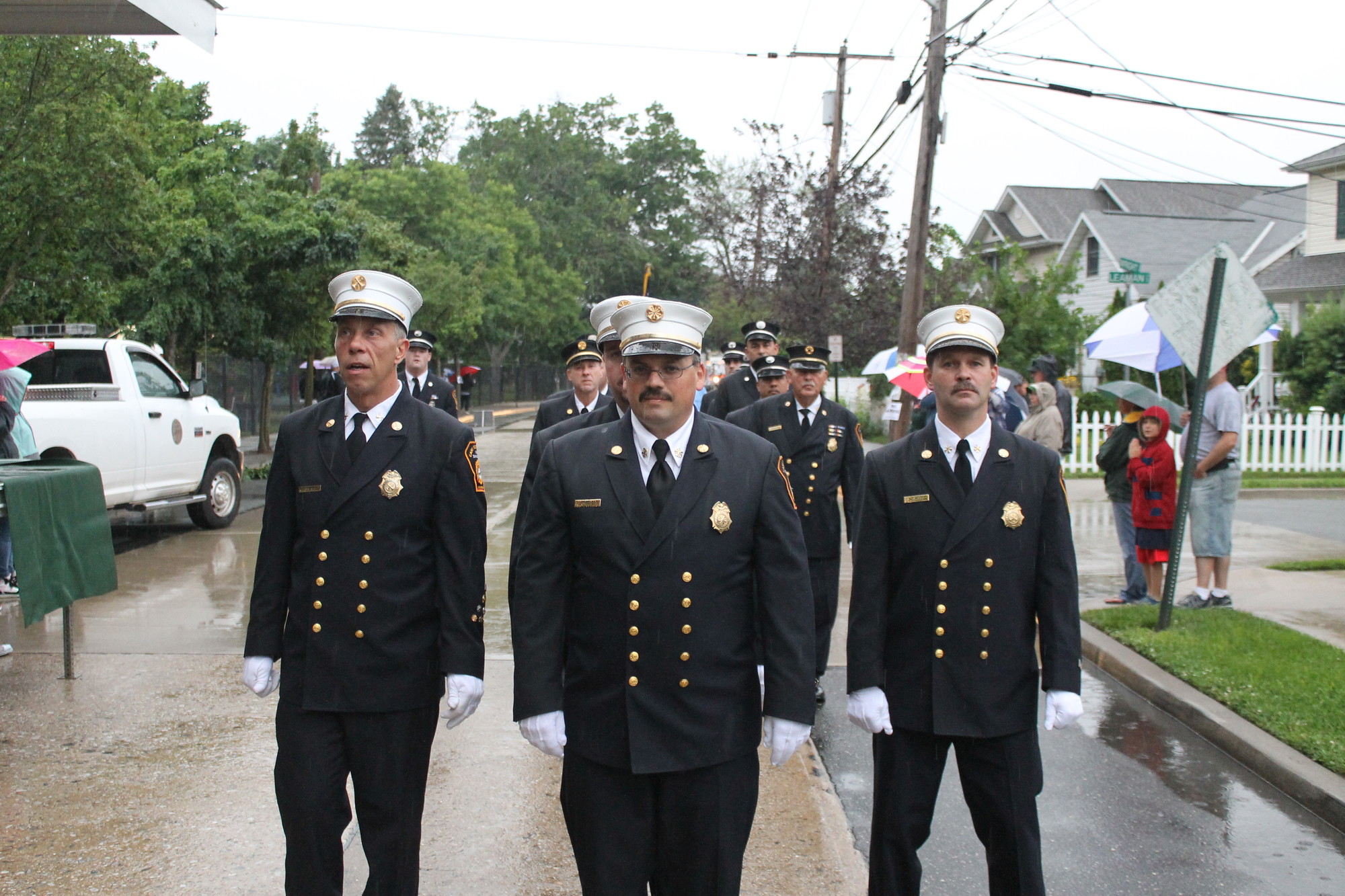 Chief Tommy Johnson, center, led his East Rockaway Fire Department members in the parade — under rainy skies.