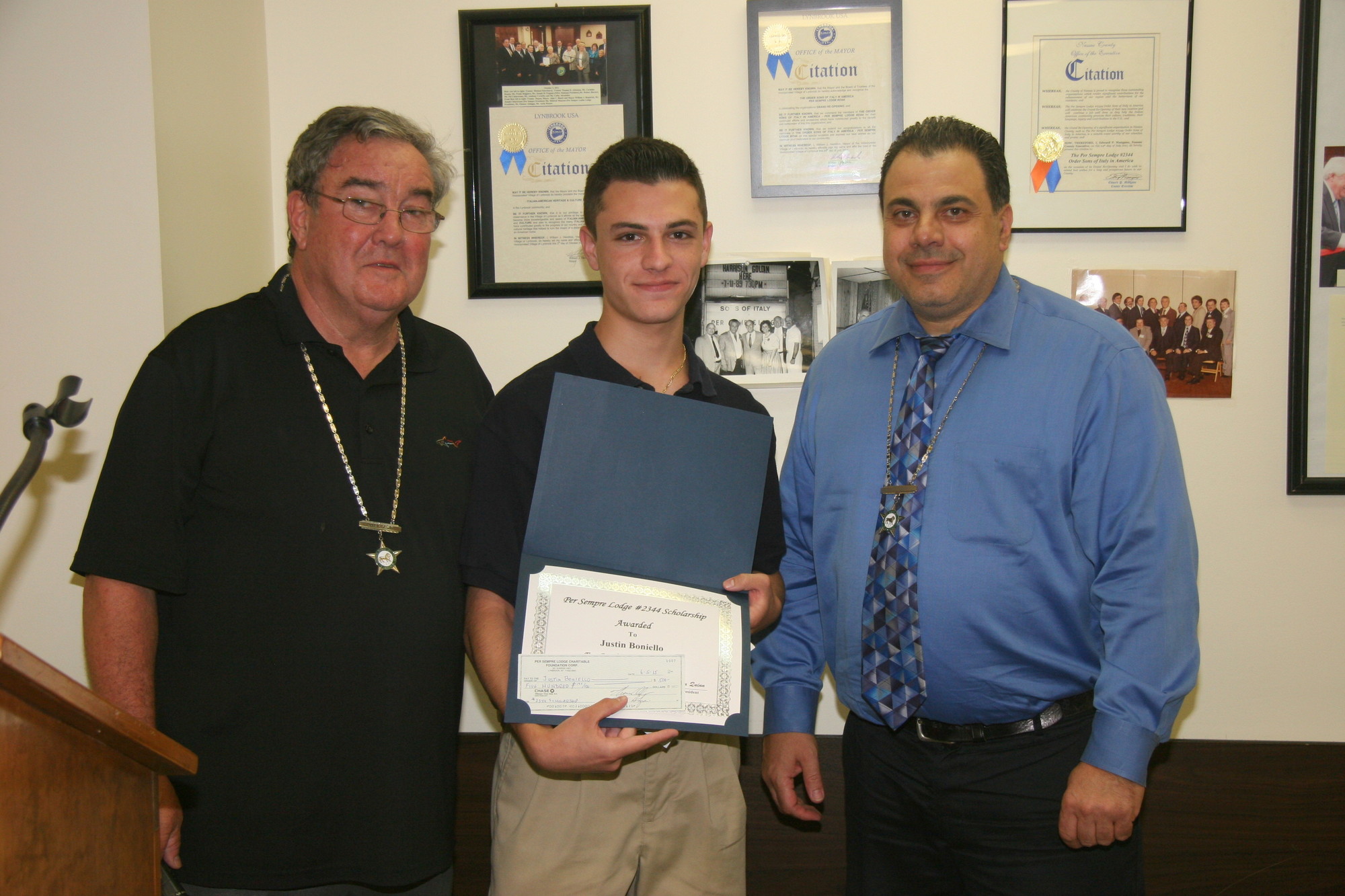 The lodge’s president, John Quinn, left, and First Vice President Gerardo Filippone, right, congratulated student Justin Boniello on being presented with his merit scholarship.