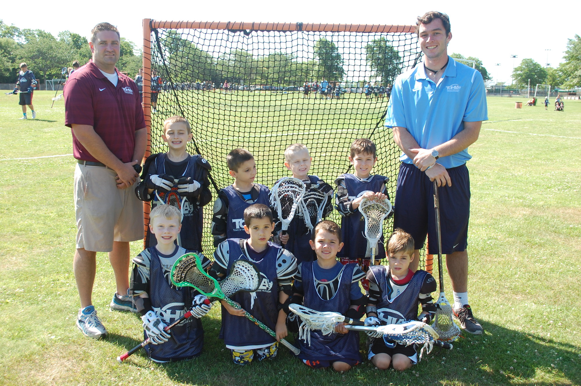 Lacrosse Academy Assistant Director Ryan Kelly, left, and coach Connor Buckley, right, with the Seaford team during last week’s clinic at Seaman’s Neck Park.