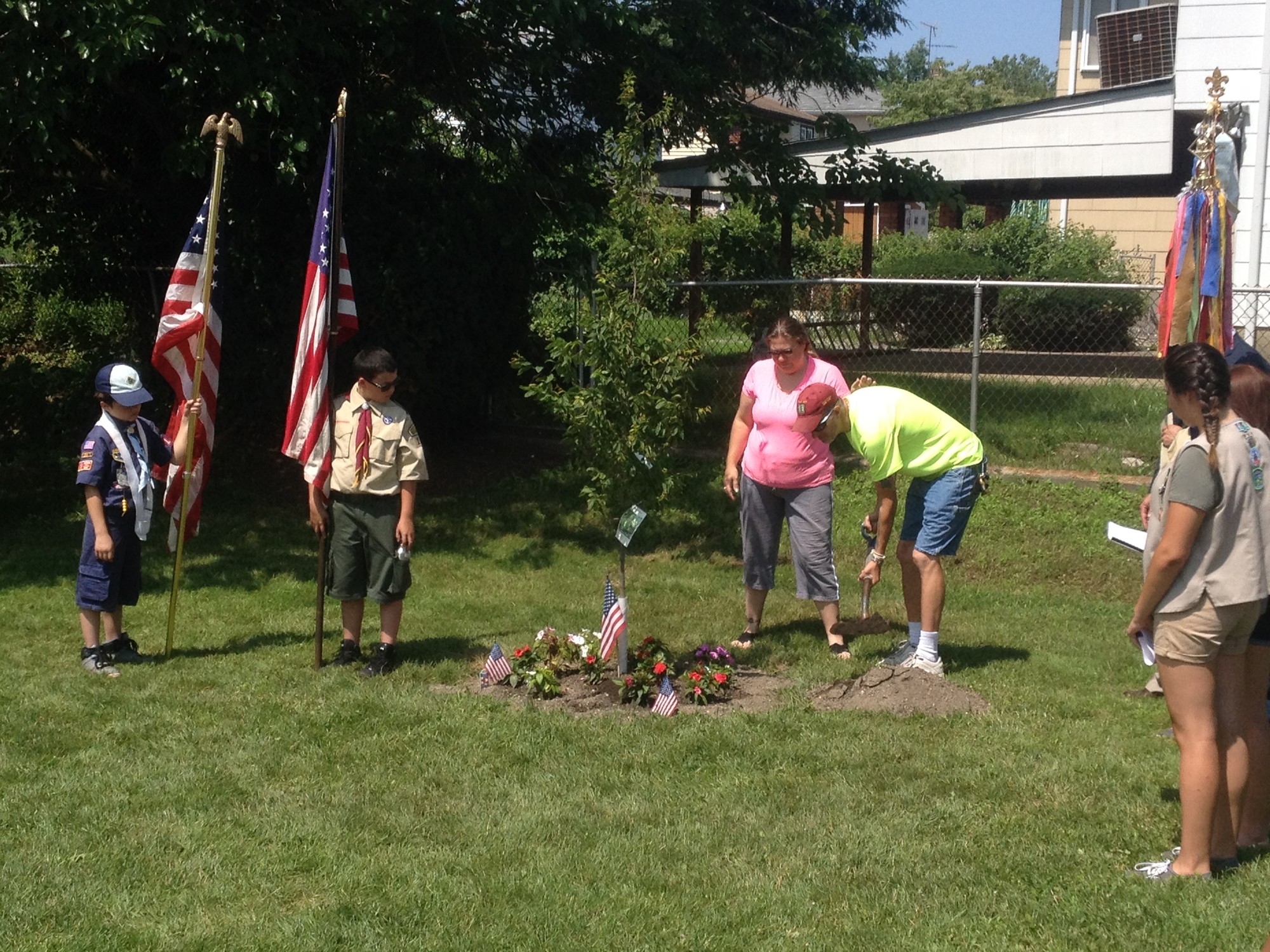 Zachary Ranftle's parents, Kathleen and Patrick Flood, center, shoveled dirt onto the spot where a tree was planted in Zachary's memory.