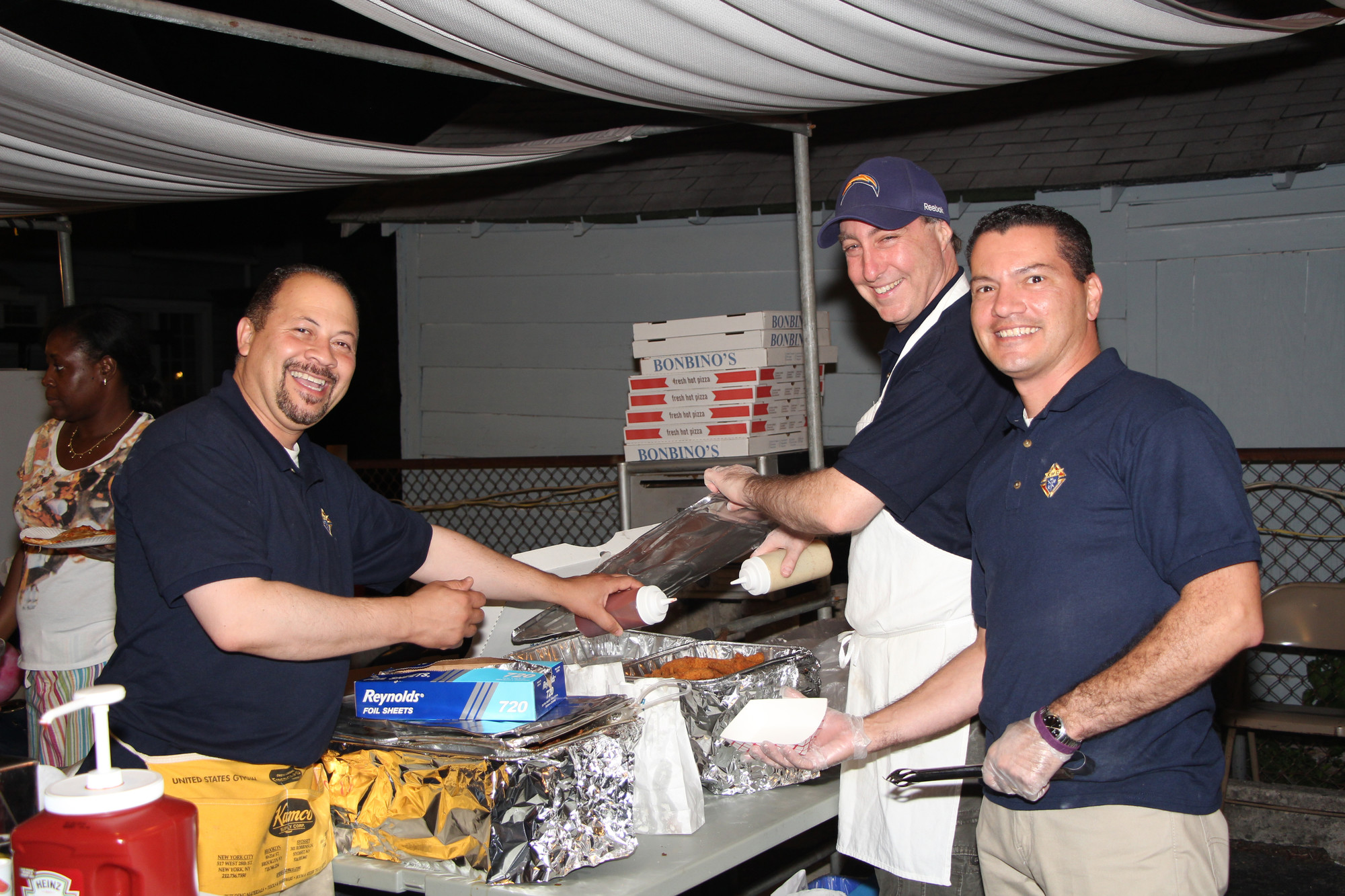 There was a variety of food offered at the St. Christopher’s Feast from July 16 to 19, including items served by volunteers, from left, Herm Pietrera, Richard Ratabolli and Jonathan Rodriguez.