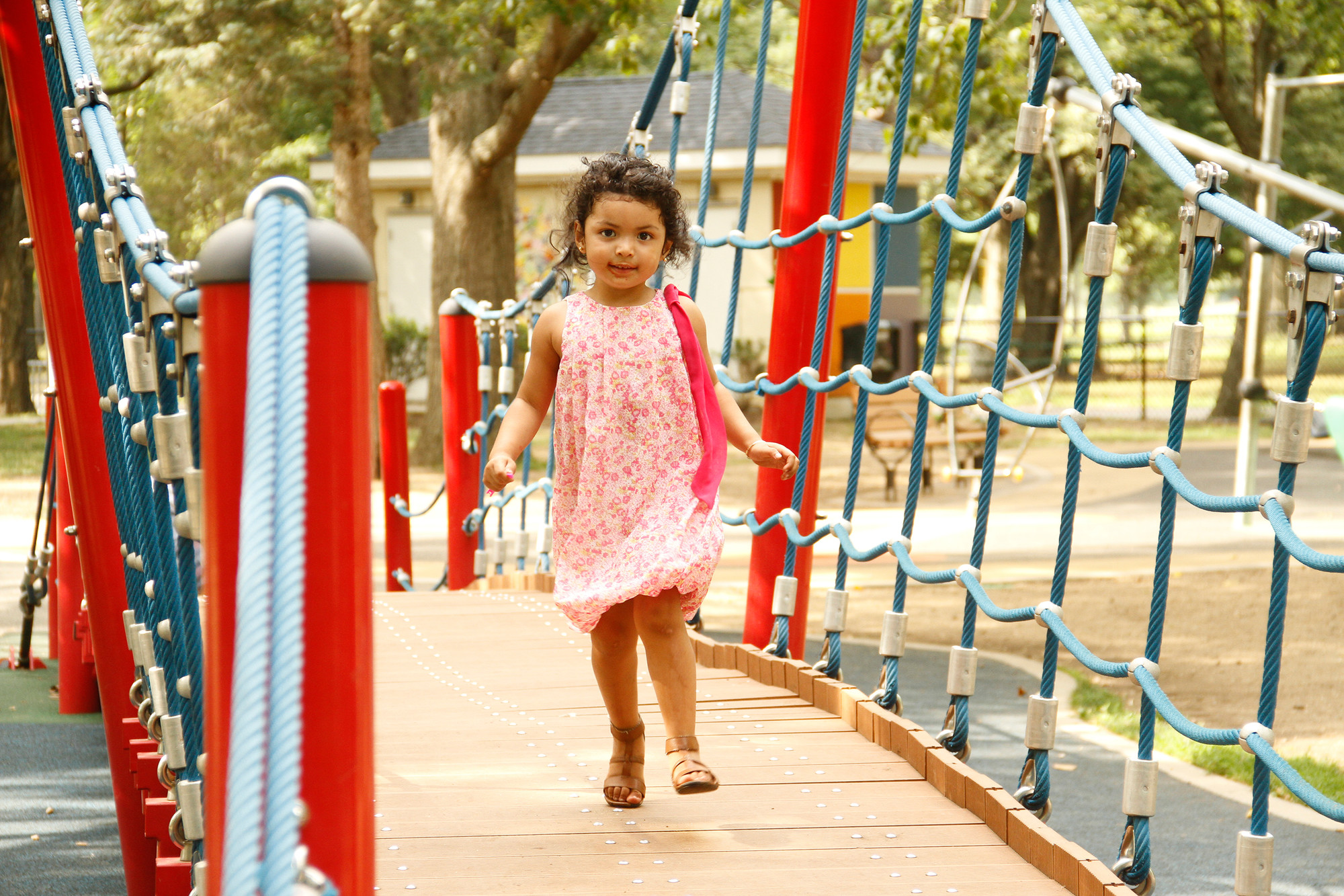 3-year-old Bridget ran across a spacious drawbridge at the park.