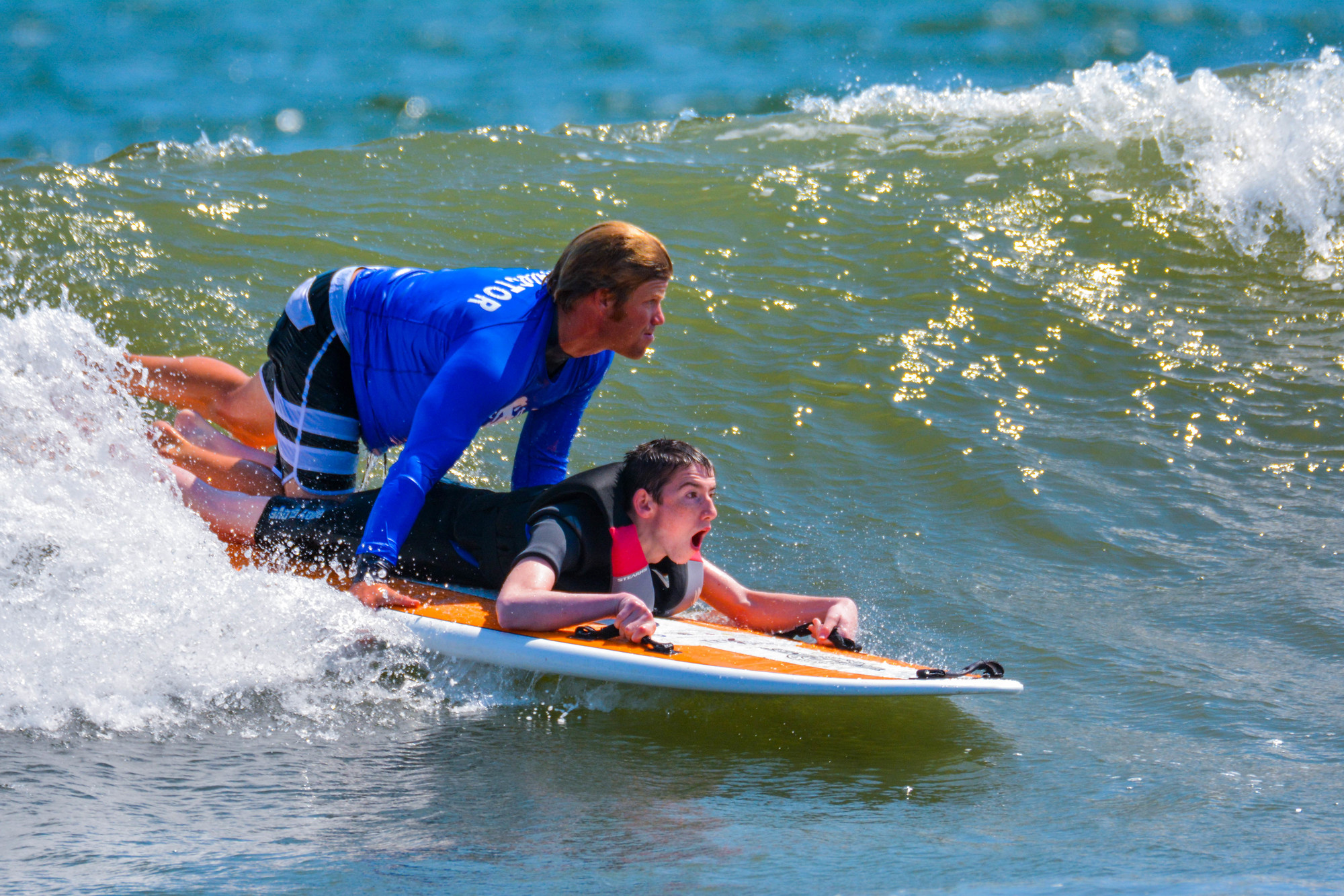 Cliff Skudin and Henry Viscardi School student Chris Scharrer catch a wave.