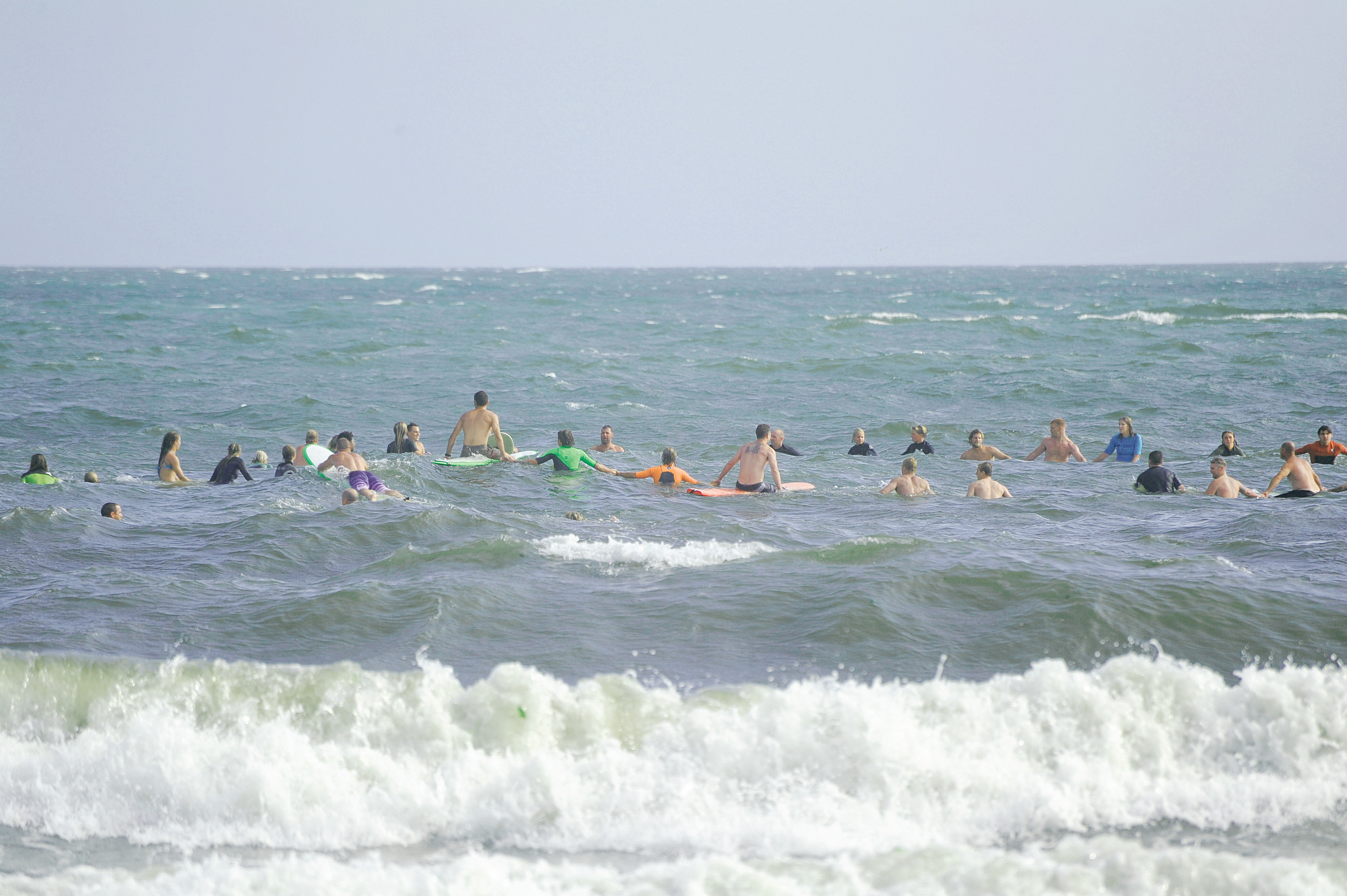 Surfers headed out for the memorial paddle-out. Each year Surf Week is dedicated to the memory of the late George “Geeza” Geiser.