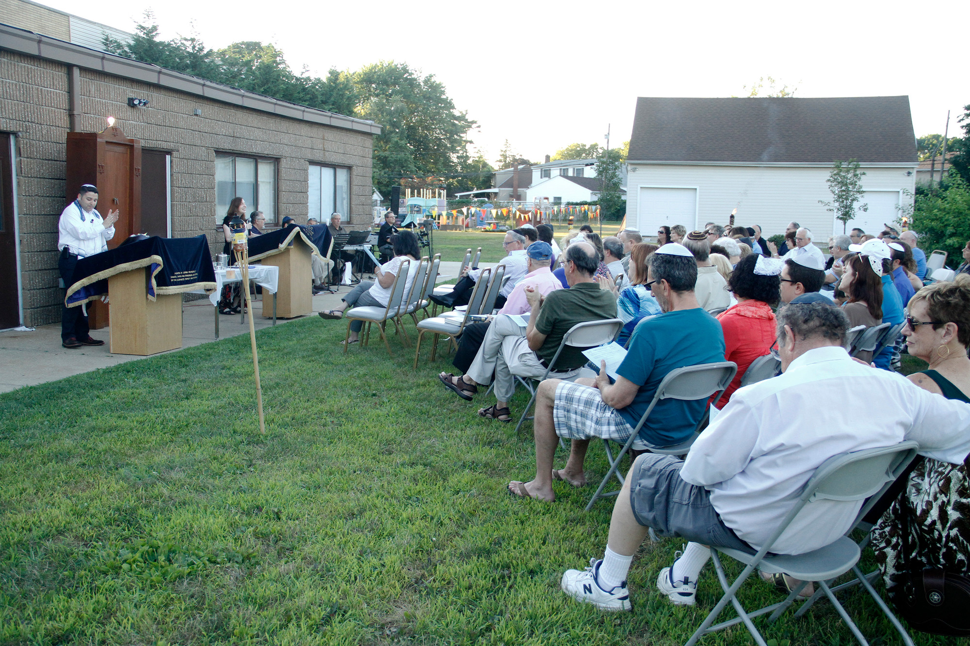 The outdoor service was held on the synagogue’s grounds, at 123   Merrick Ave., last Friday.