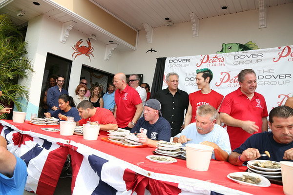 Nassau County Executive Ed Mangano, champion eater Takeru Kobayashi and Peter’s Clam Bar owner Butch Yamali watched as contestants consumed large quantities of clams last year. (Courtesy Peter’s Clam Bar)