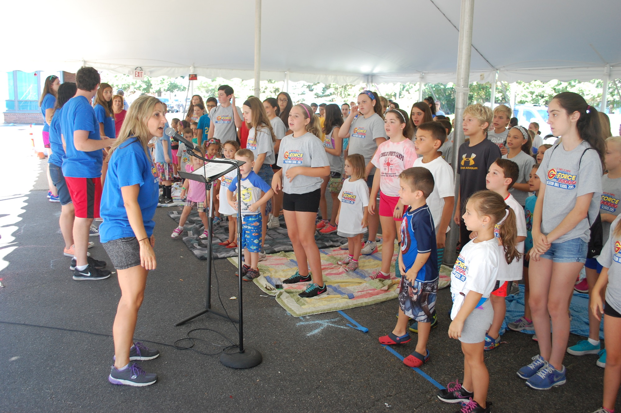 Each day’s program began with songs under the tent, led by Music Director Lisa Fucarino, left.