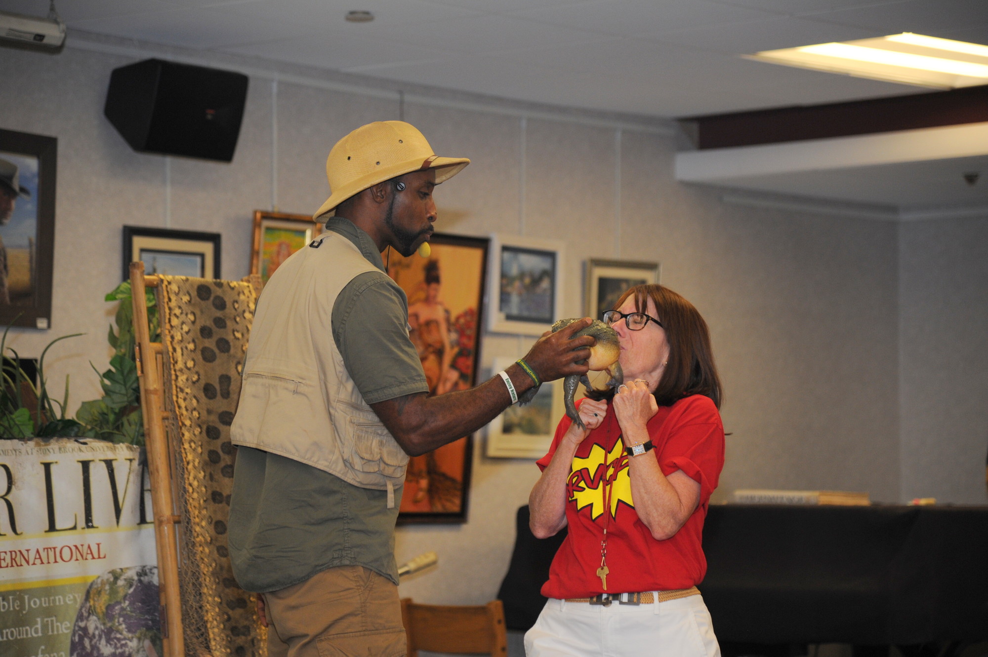 Librarian Terry Ain kissed the bullfrog that Erik Callendar brought to the Rockville Centre Public Library as part of his traveling show on reptiles, amphibians and other cool and creepy creatures. (Donovan Berthoud/Herald)