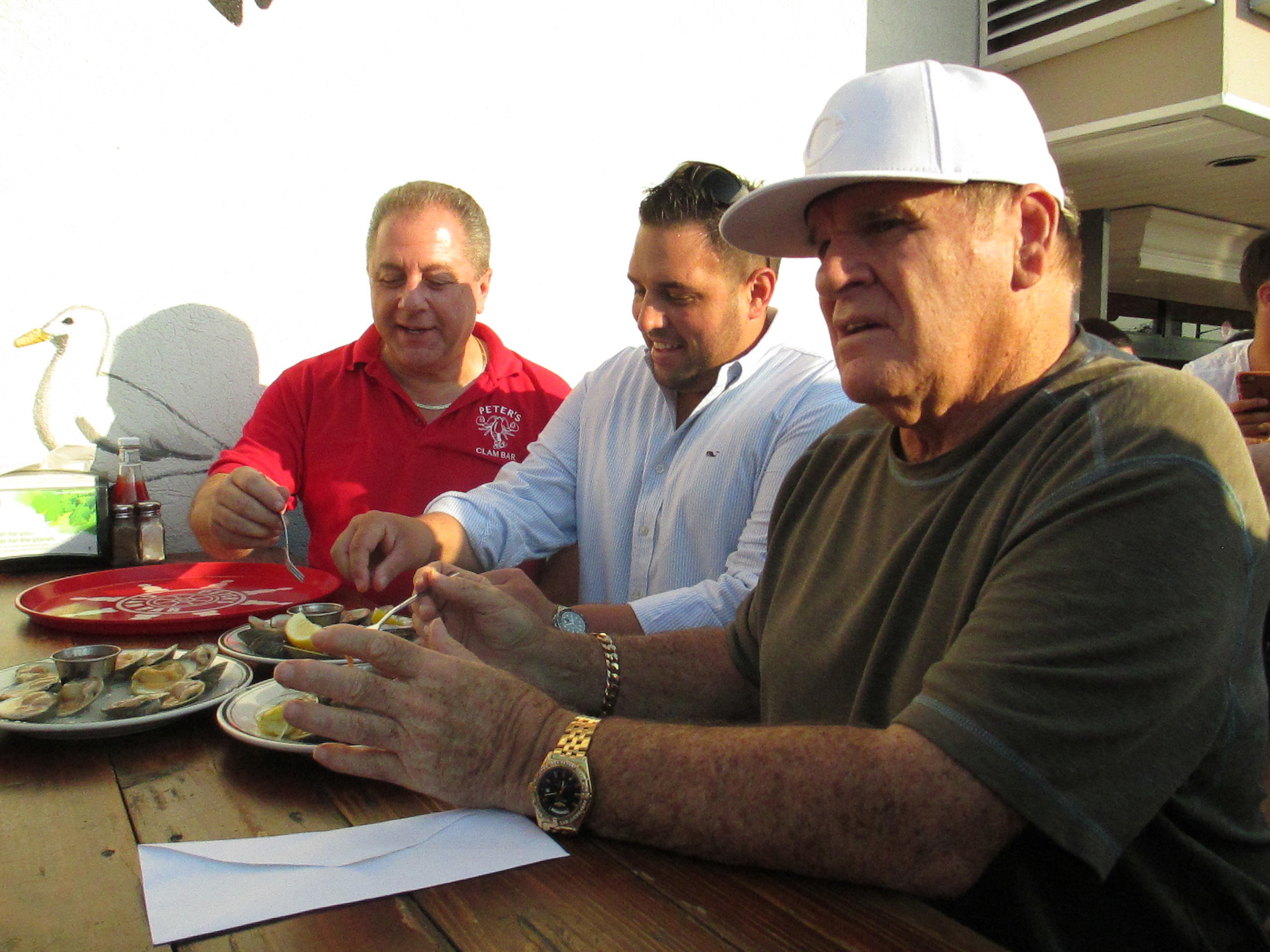 Peter’s Clam Bar owner Butch Yamali left, Island Park Third Assistant Fire Chief Anthony D’Esposito, center,  with baseball legend Pete “Charlie Hustle” Rose, who was inducted into the Peter’s Clam Eating Hall of Fame.