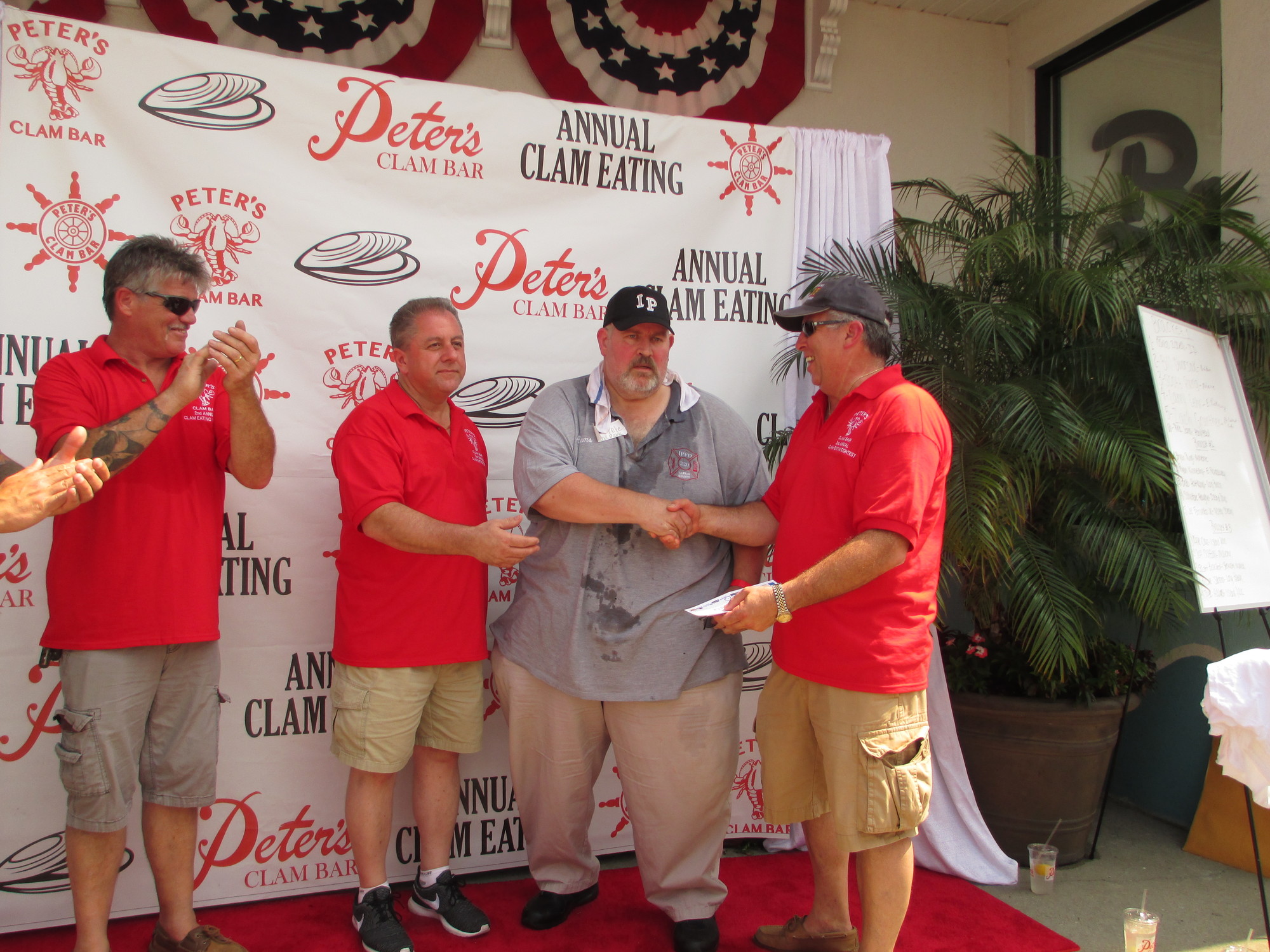 The winner, Pete Adams, center, of the Island Park F.D., was congratulated by Peter’s owner Butch Yamali, left, and Chief Ed Madden of the IPFD, right.