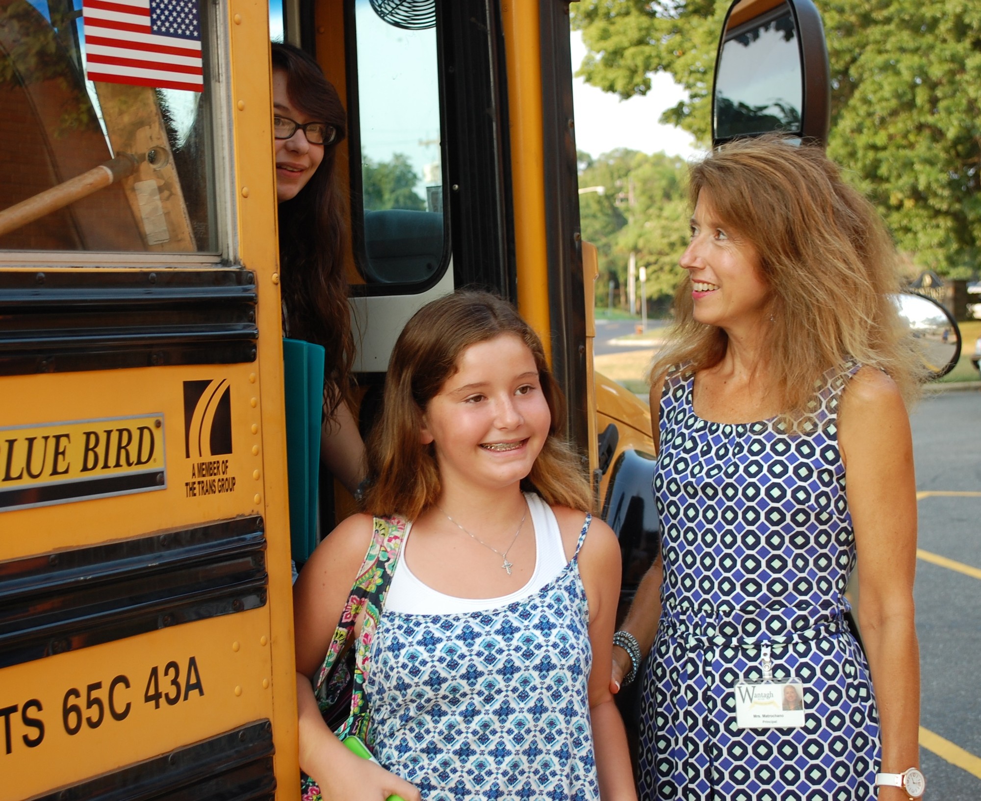 Middle School Principal Dawn Matrochano greeted seventh-grader Erin Skaar, center, and eighth-grader Alexis Argento, the first students off the first bus on the first day.