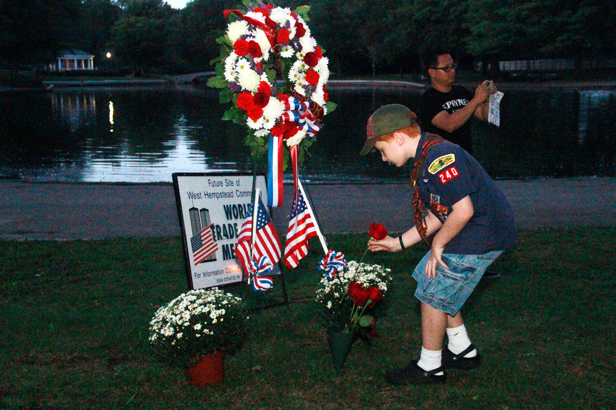 Sean Leno of Boy Scout Troop 240 placed a flower at the memorial. (Susan Grieco/Herald)