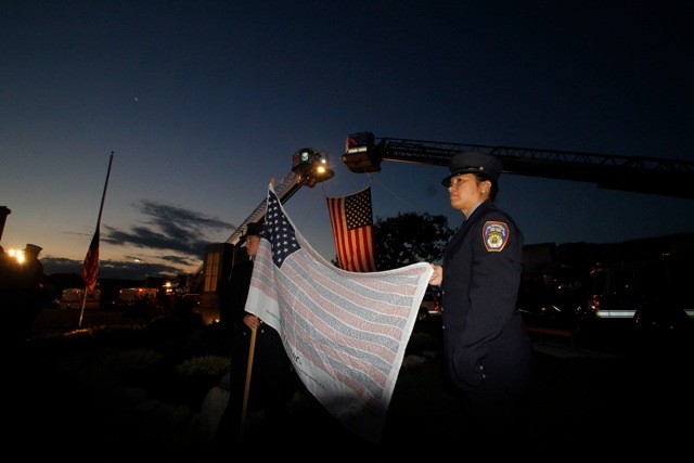 Left, Caroline Nokes, Firefigher, and Angela Rondinella, rescue, proudly holds the flag with the names of civilans who died in the September 11th attacks.