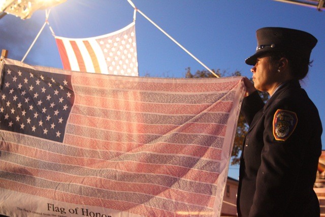 Angela Rondinella, rescue, proudly holds the flag with the names of civilans who died in the September 11th attacks.