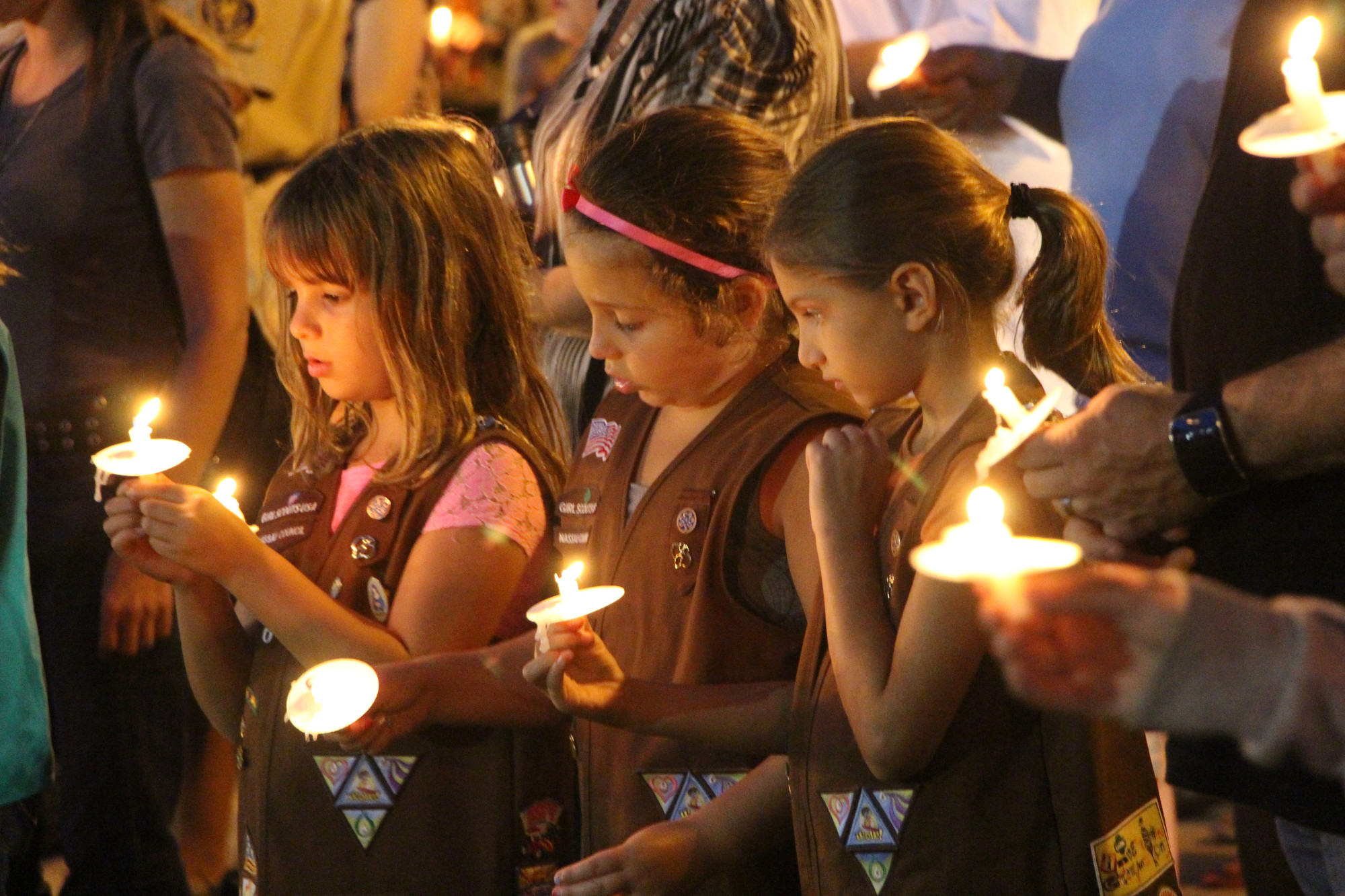 East Meadow Girl Scout Brownies Amanda Morris, 8, far left, Juliana Alagna, 7, and Erin Schwartz, 8, were among 300 residents who lit a candle last week in
remembrance of the thousands who died on Sept. 11, 2001.