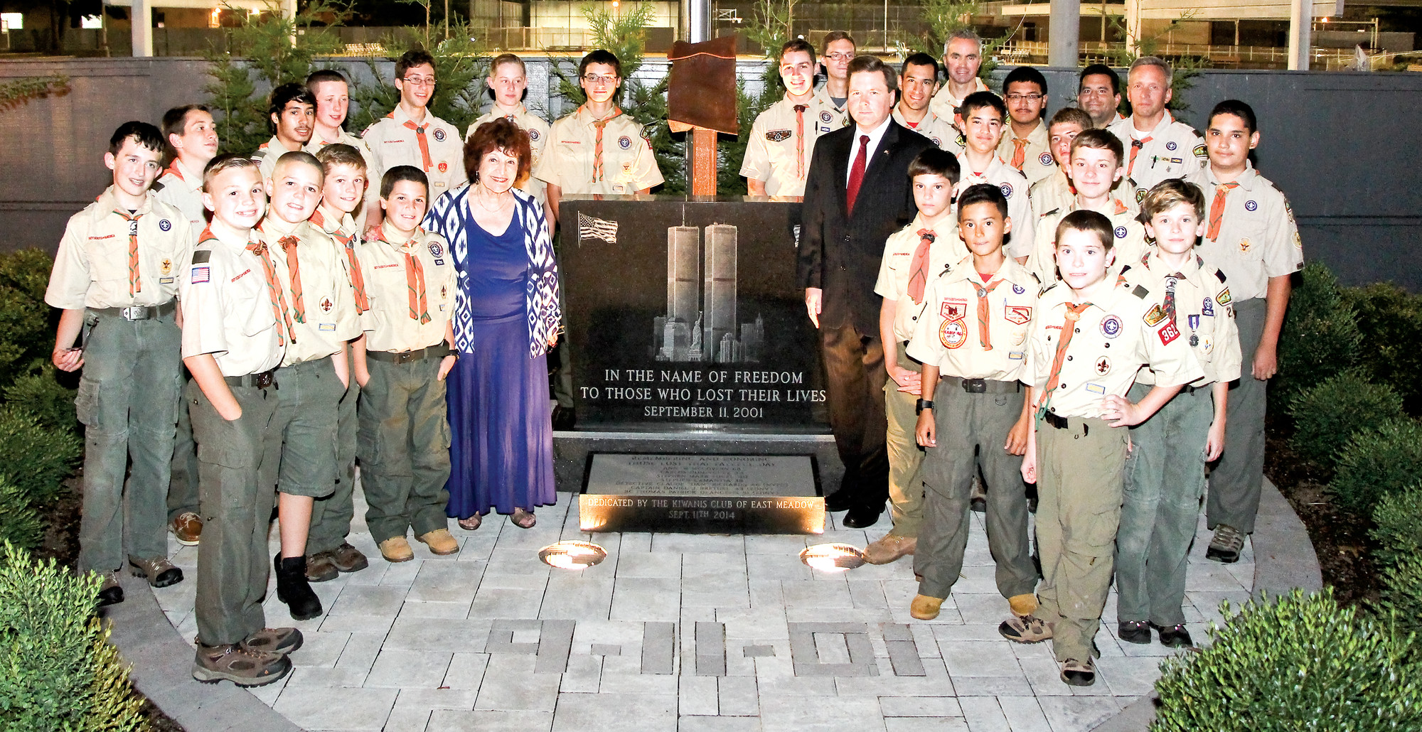 East Meadow Boy Scouts of Troop 362, with Nassau County Legislature Presiding Officer Norma Gonsalves and Assemblyman Tom McKevitt, at the Sept. 11 memorial in Veterans Memorial Park, which lists the names of the seven local residents who died 14 years ago in the World Trade Center attacks.