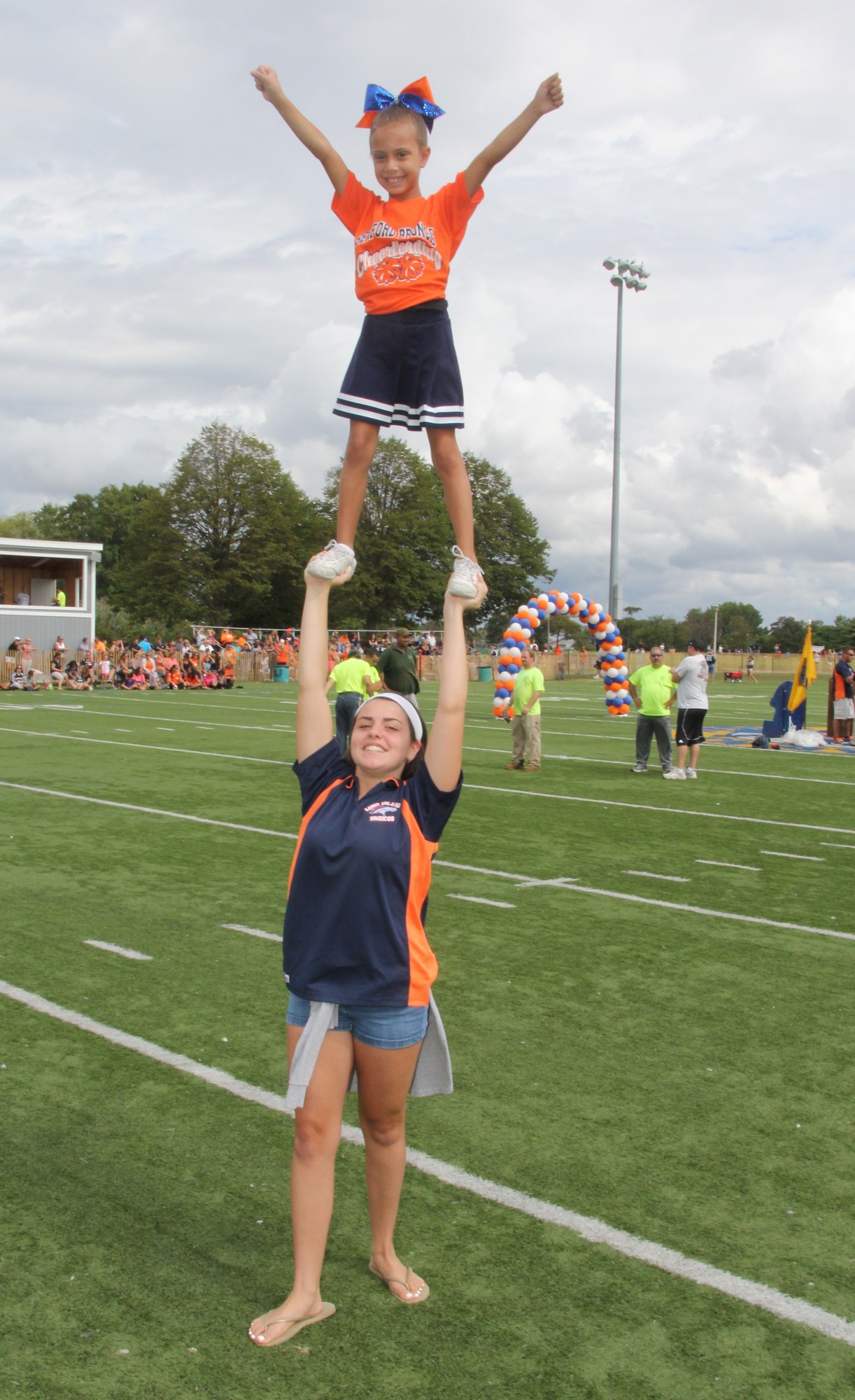 Madison Uher, 14, held Kayleigh Elias, 7, during a cheerleading routine to celebrate the beginning of the Long Island Broncos football season at Seaman’s Neck Park in Seaford.