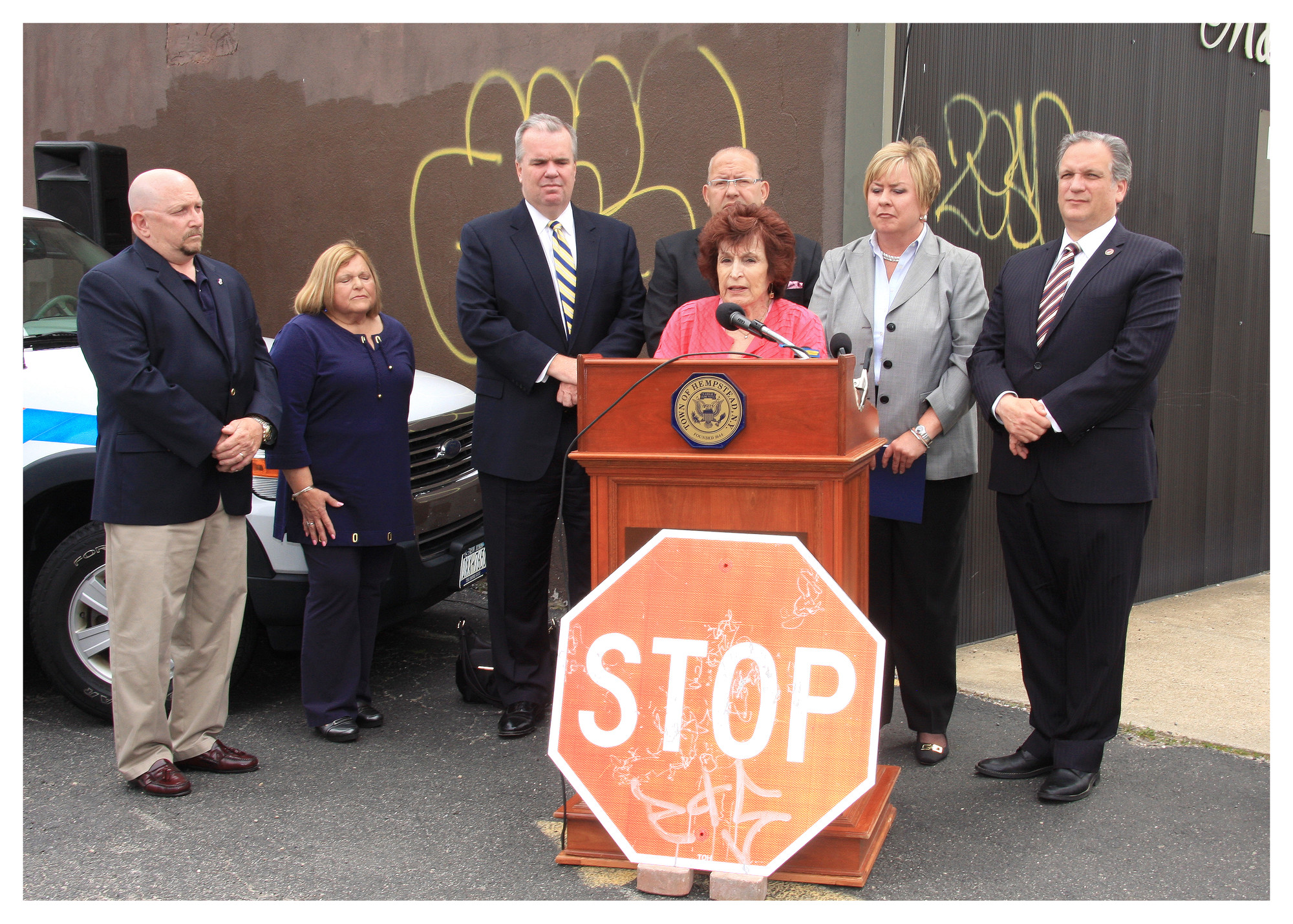 Community and elected leaders first convened in East Meadow in May to announce a partnership to combat graffiti. Behind the Nassau County Legislature’s presiding officer, Norma Gonsalves, at lectern, were, from far left,  residents Rich Bivone and Helen Meittinis, Acting County Police Commissioner Thomas Krumpter, Town of Hempstead Councilman Gary Hudes, Town Supervisor Kate Murray and County Executive Ed Mangano.
