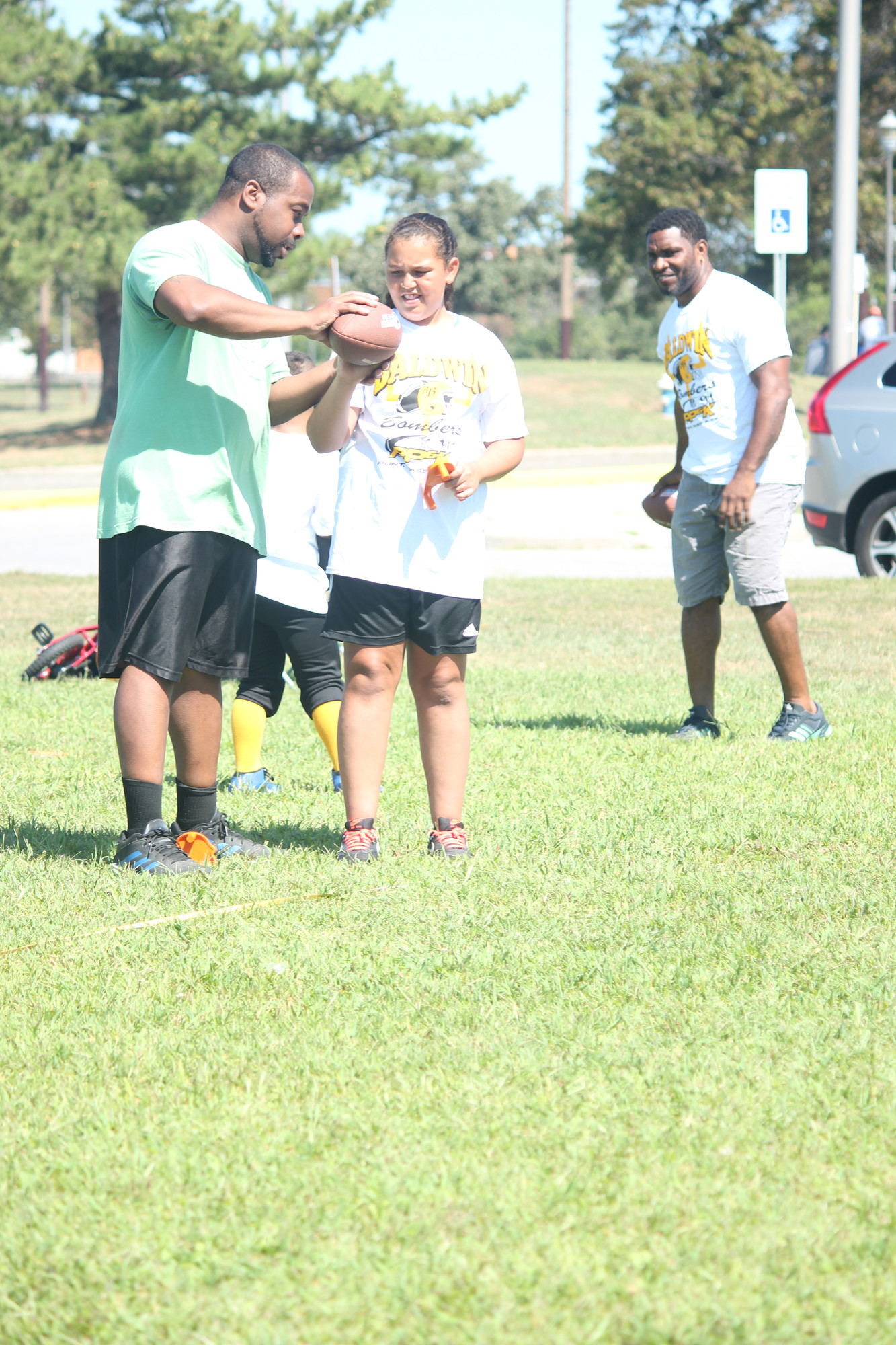 Who says football is just for men? Sahara Wilks, 10, listens to throwing pointers from coach Garris Williams.