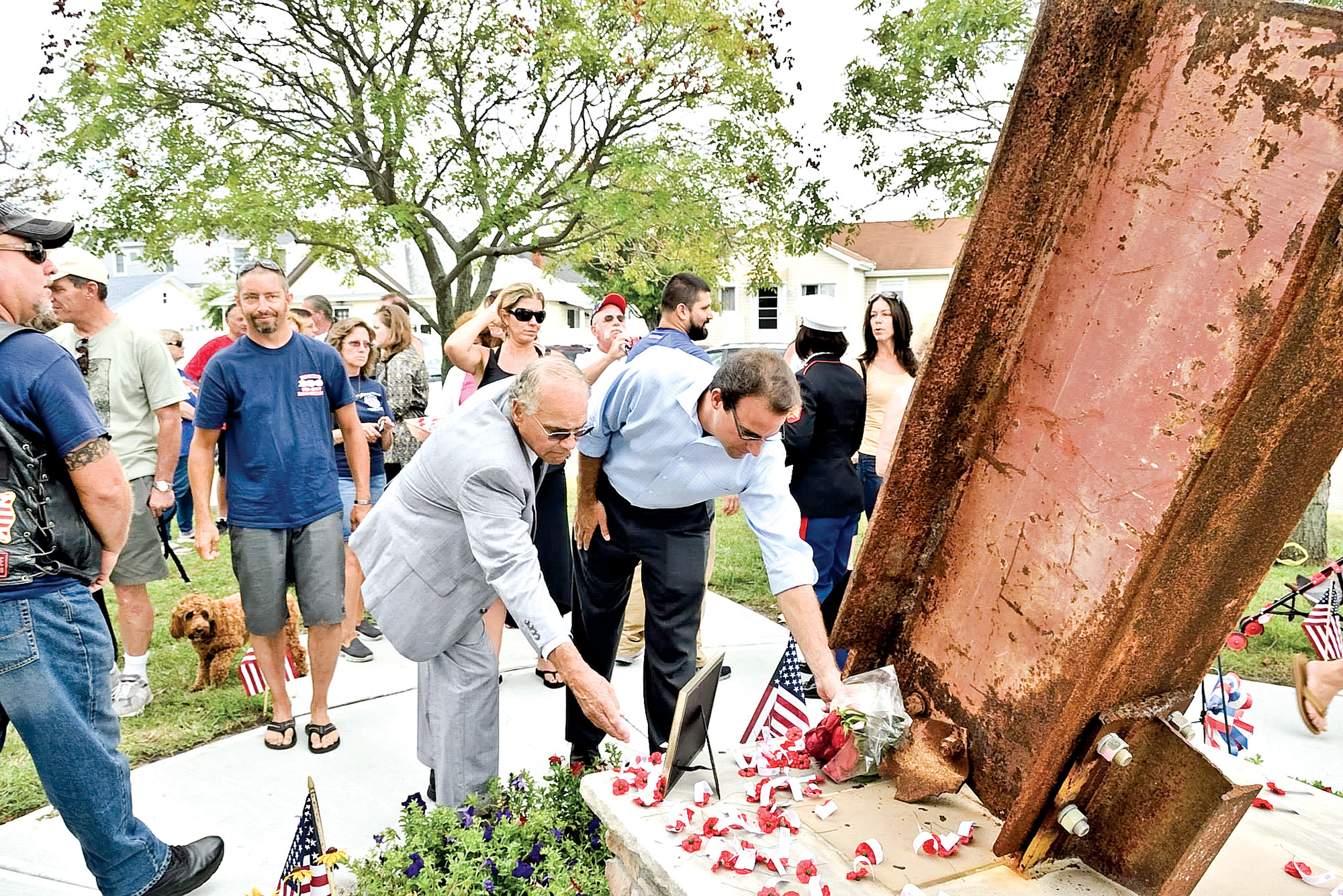 City Council President Len Torres, left, and Councilman Anthony Eramo addressed the crowd at Sunday’s dedication ceremony and placed flowers at the base of the monument.