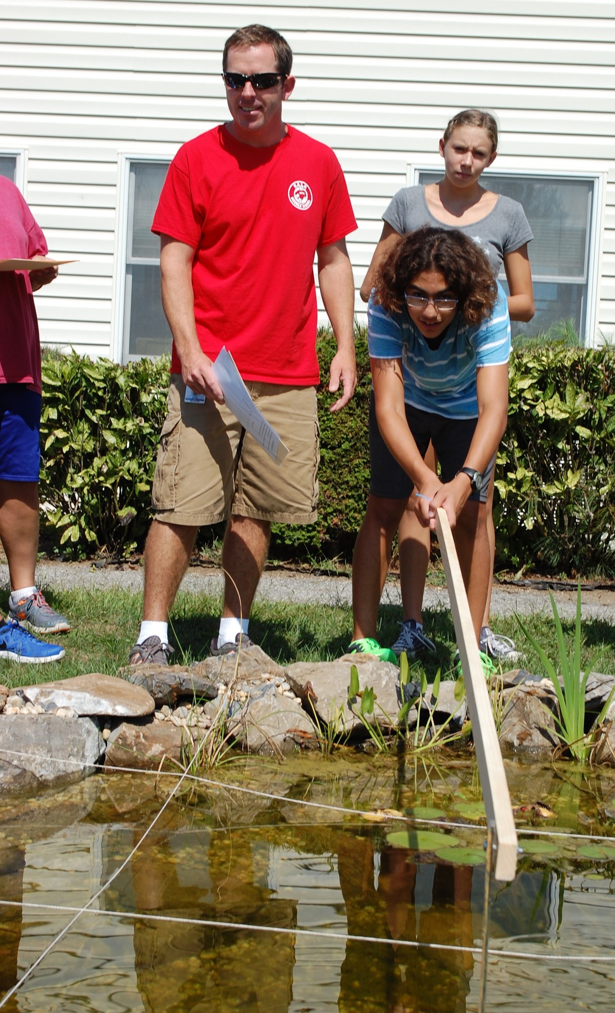 Eighth-grader Macedonio Cicala measured the depth of the pond with the assistance of science teacher Paul Zaratin.