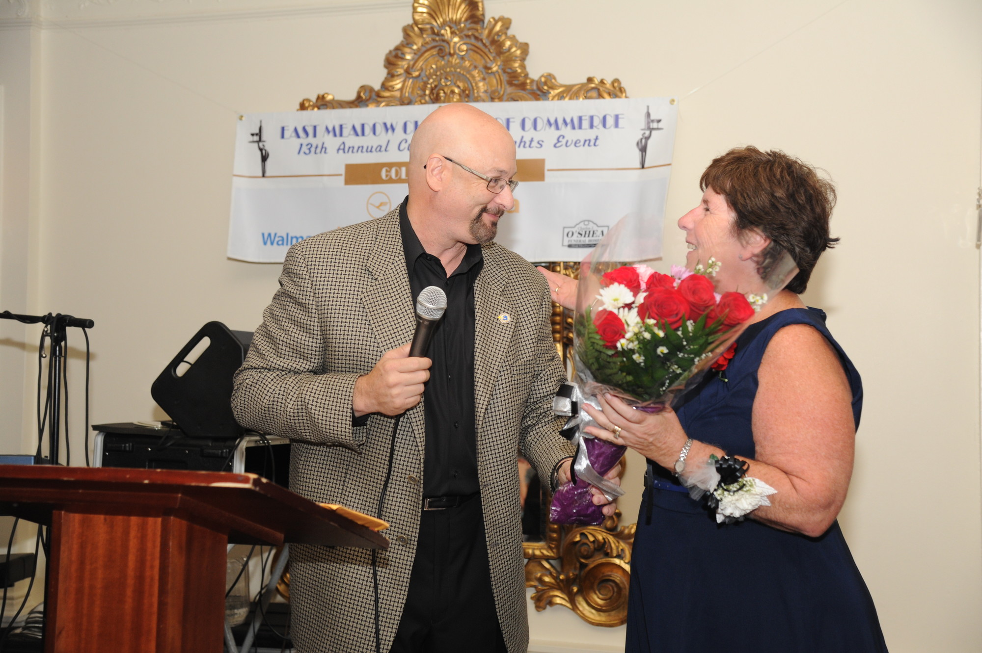 Chamber President Mitchell Allen handed flowers to Linda Walsh, of the Nassau University Medical Center, who is retiring after 33 years.