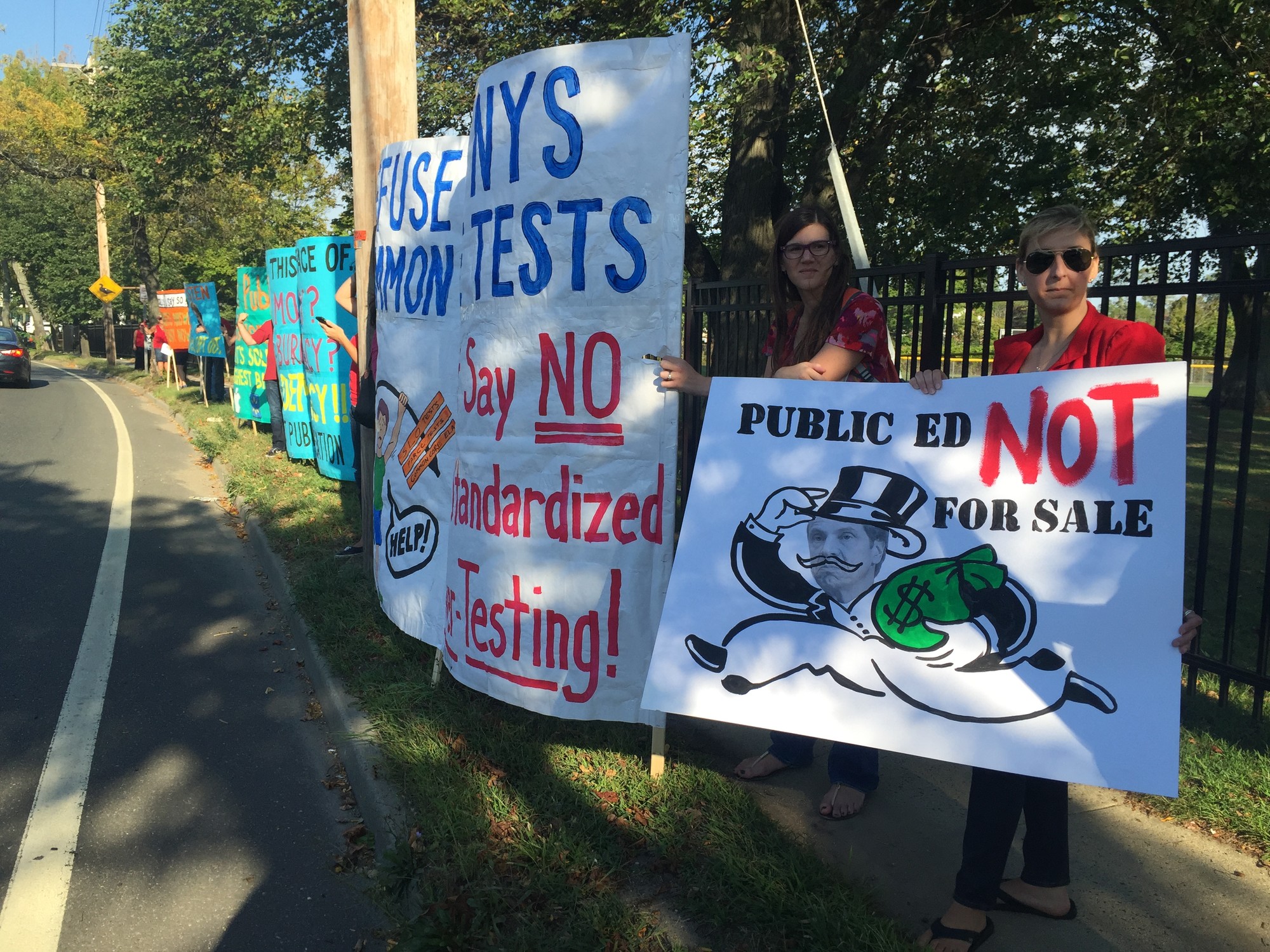 Bellmore-Merrick parents and teachers in the elementary and high school districts gathered on Merrick Road for a rally for public education reform on Sept. 17. Mepham High School leave-replacement teacher Lisa Ralish, right, was one of the many who made their own colorful signs.