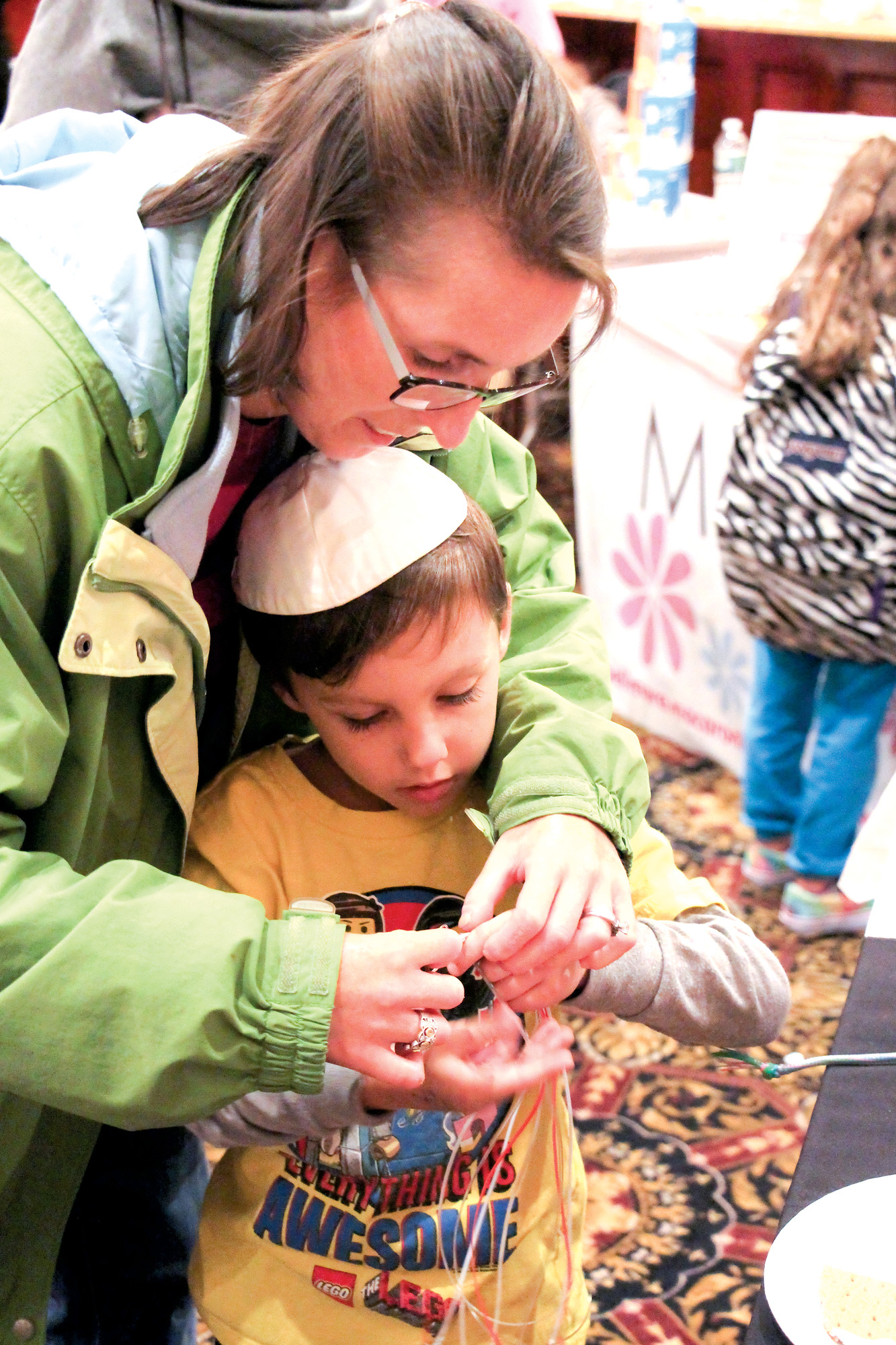 Kirsten Rachaf helped her son, Benjamin, 5, make a keychain at one of the many arts and crafts booths.