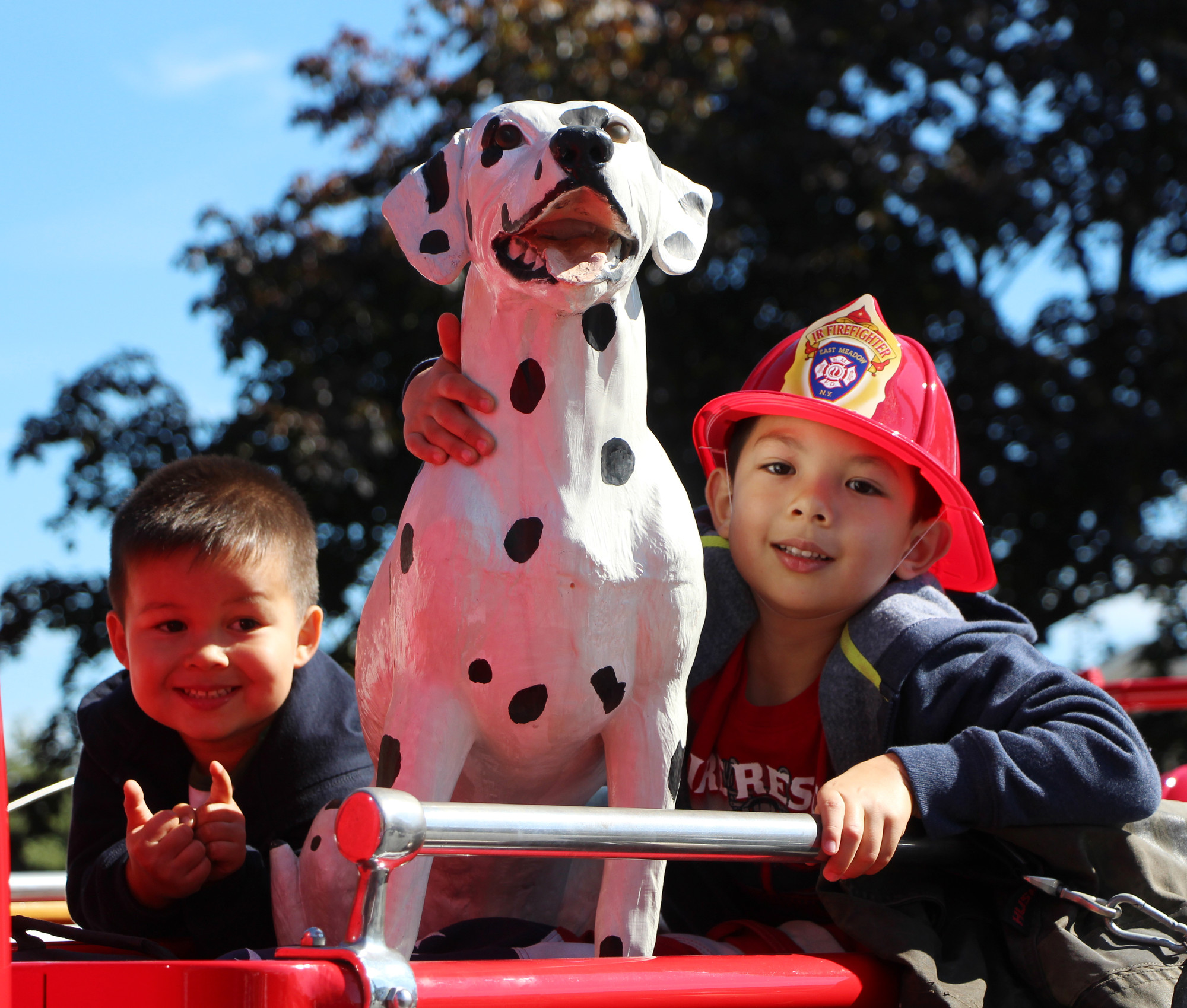 Ryan Chan, 3, and his brother, Joshua, 4, with every firefighter’s favorite spotted companion last Sunday at the East Meadow Fire Department’s Open House.