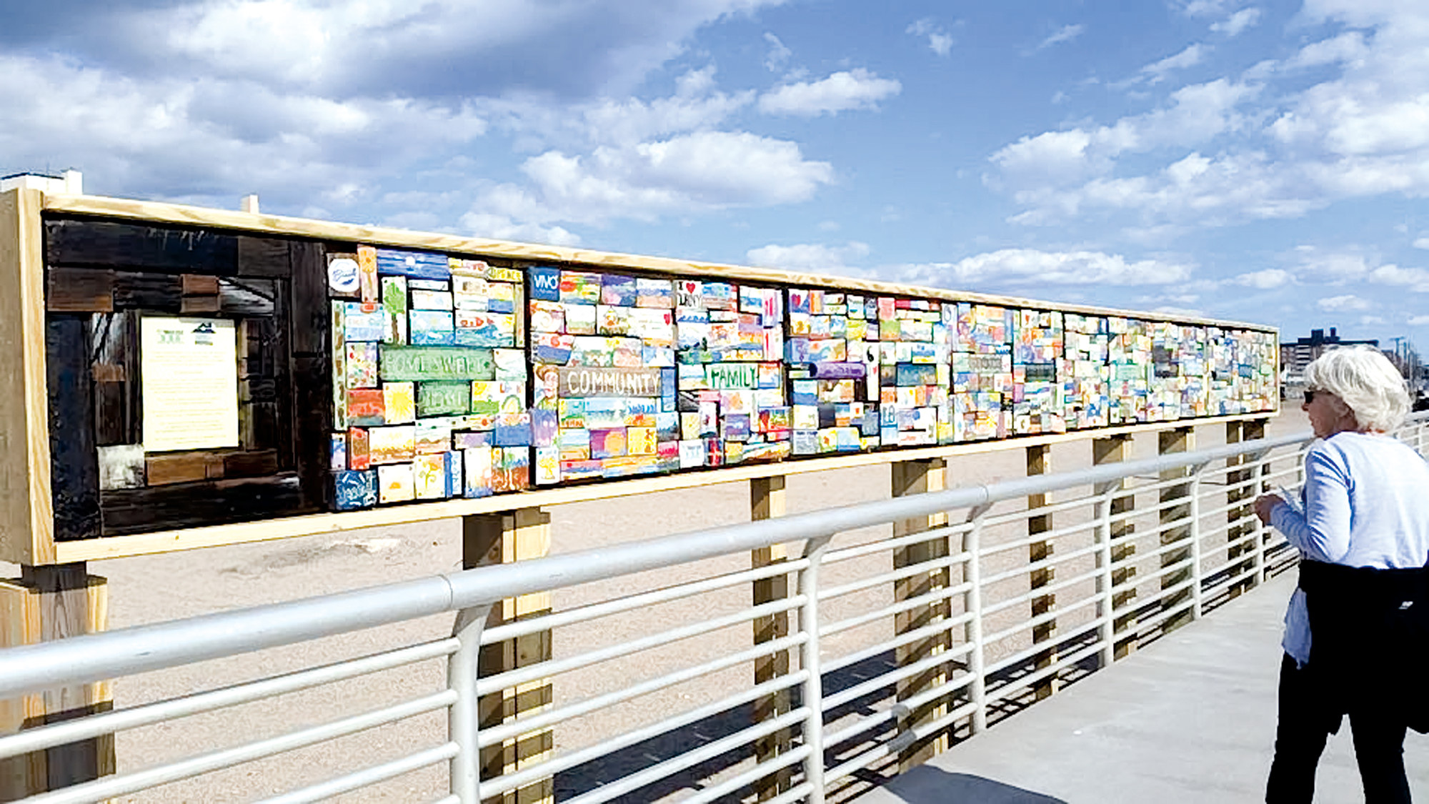 Courtesy West End Arts/Facebook The newly finished installation is composed of 14 square panels made of repurposed wood from the original boardwalk and painted by residents.