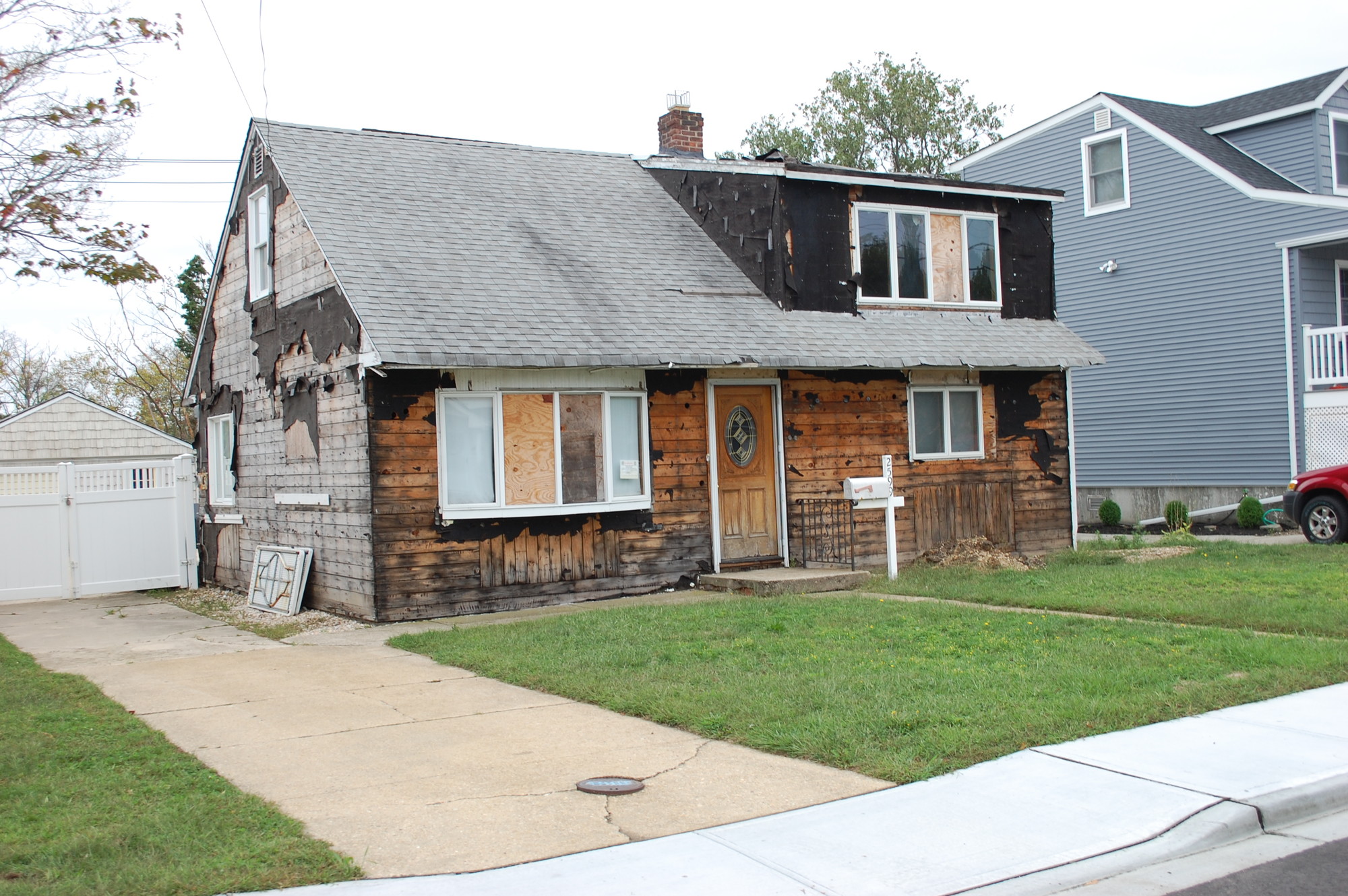A home on Wantagh Avenue that is still awaiting repairs after Hurricane Sandy sits between one up for auction and another that has been raised and renovated.