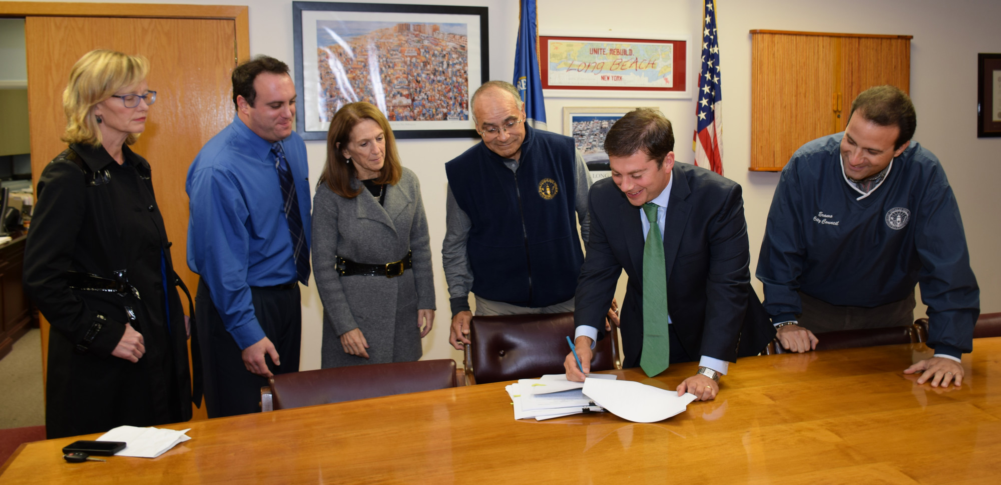 City Council members Eileen Goggin, left, Scott Mandel, Fran Adelson, Len Torres, City Manager Jack Schnirman, and Councilman Anthony Eramo look over an agreement with the state that allows the Army Corps of Engineers to formally begin its coastal protection project.