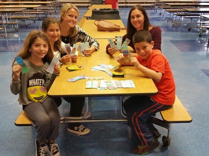 Hailey Boas, Alexis Reiner, Levy-Lakeside Assistant Principal Allison Banhazl, Book Fairies founder Amy Zaslansky and Zachary Boas held up bookmarks that students crafted as part of the book collection.