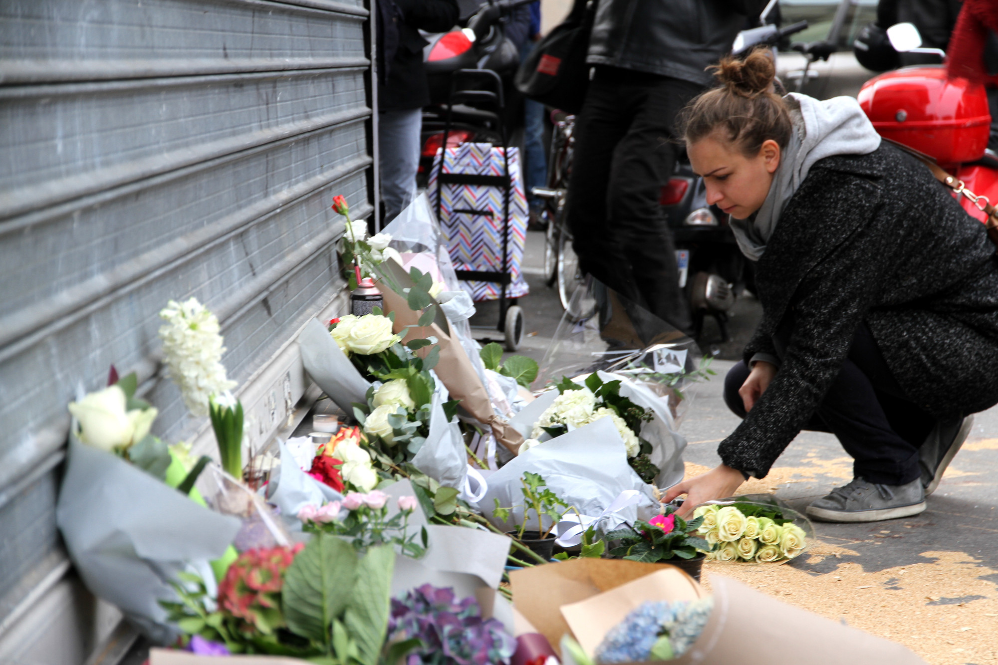 a woman laid flowers at a makeshift memorial in Paris a day after the shooting.